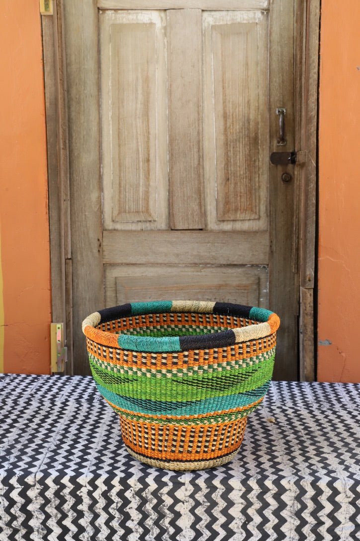 Colorful woven basket on a table with a wooden door in the background