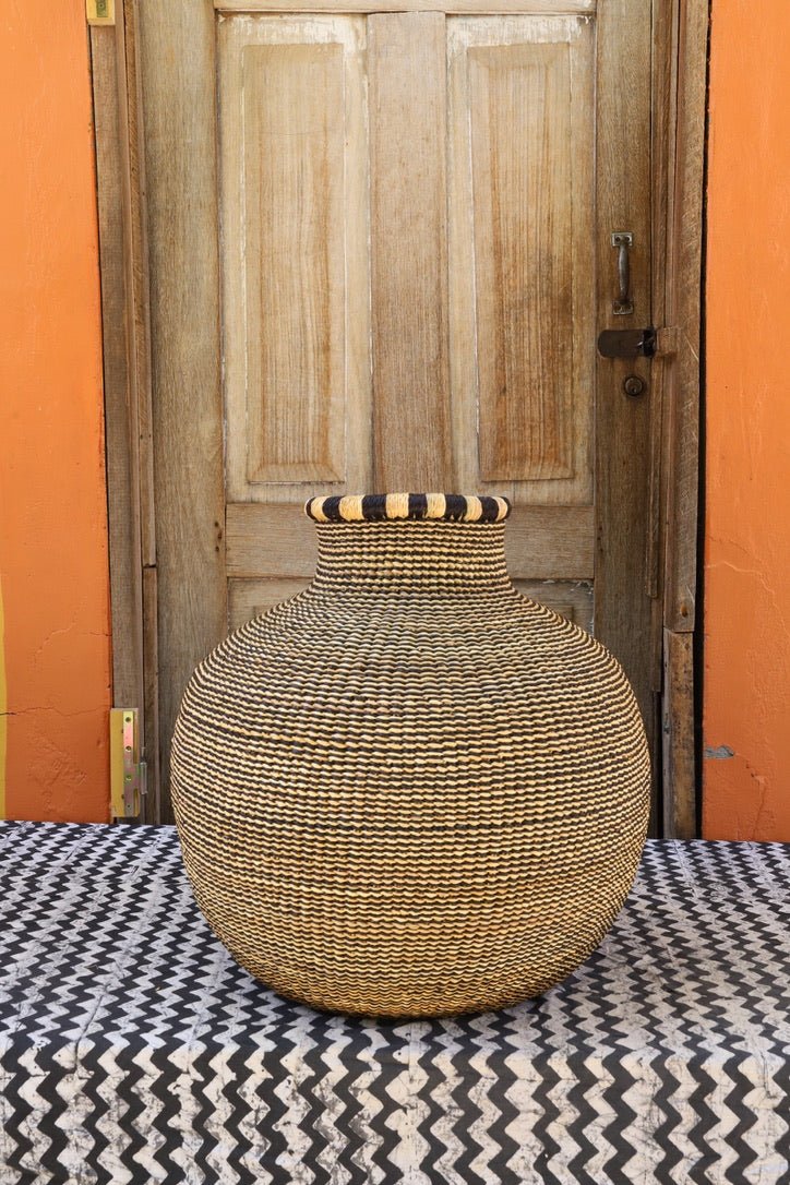 Woven basket on a patterned surface with a wooden door in the background