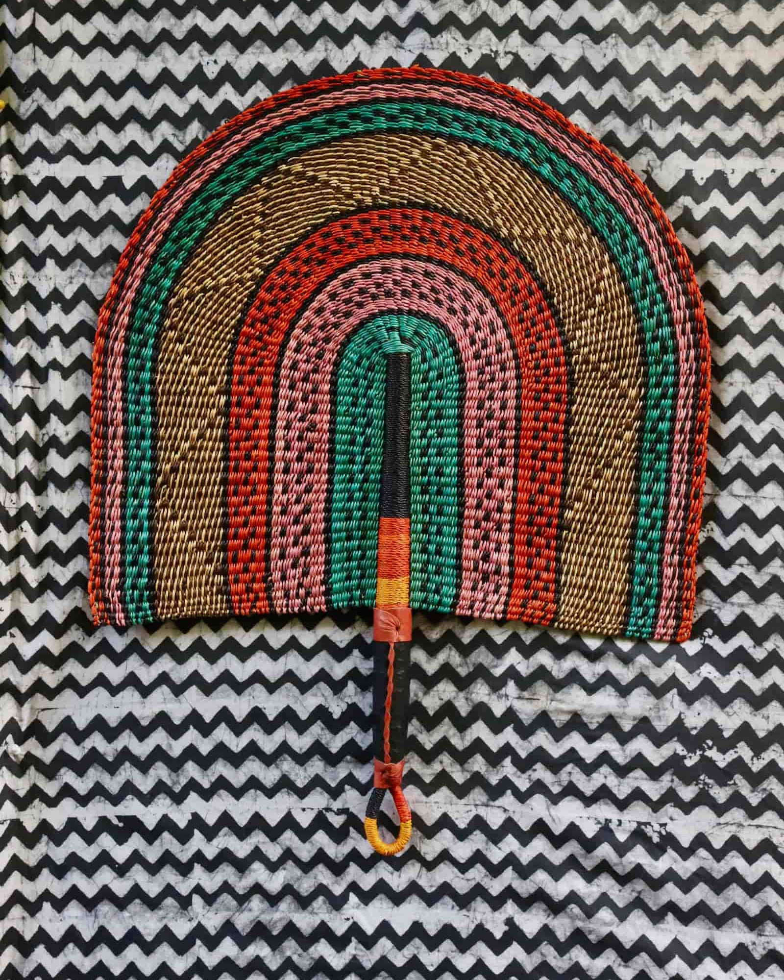 Naba Penga wall décor: teal, terracotta and pink rainbow arch, flat lay on chevron fabric
