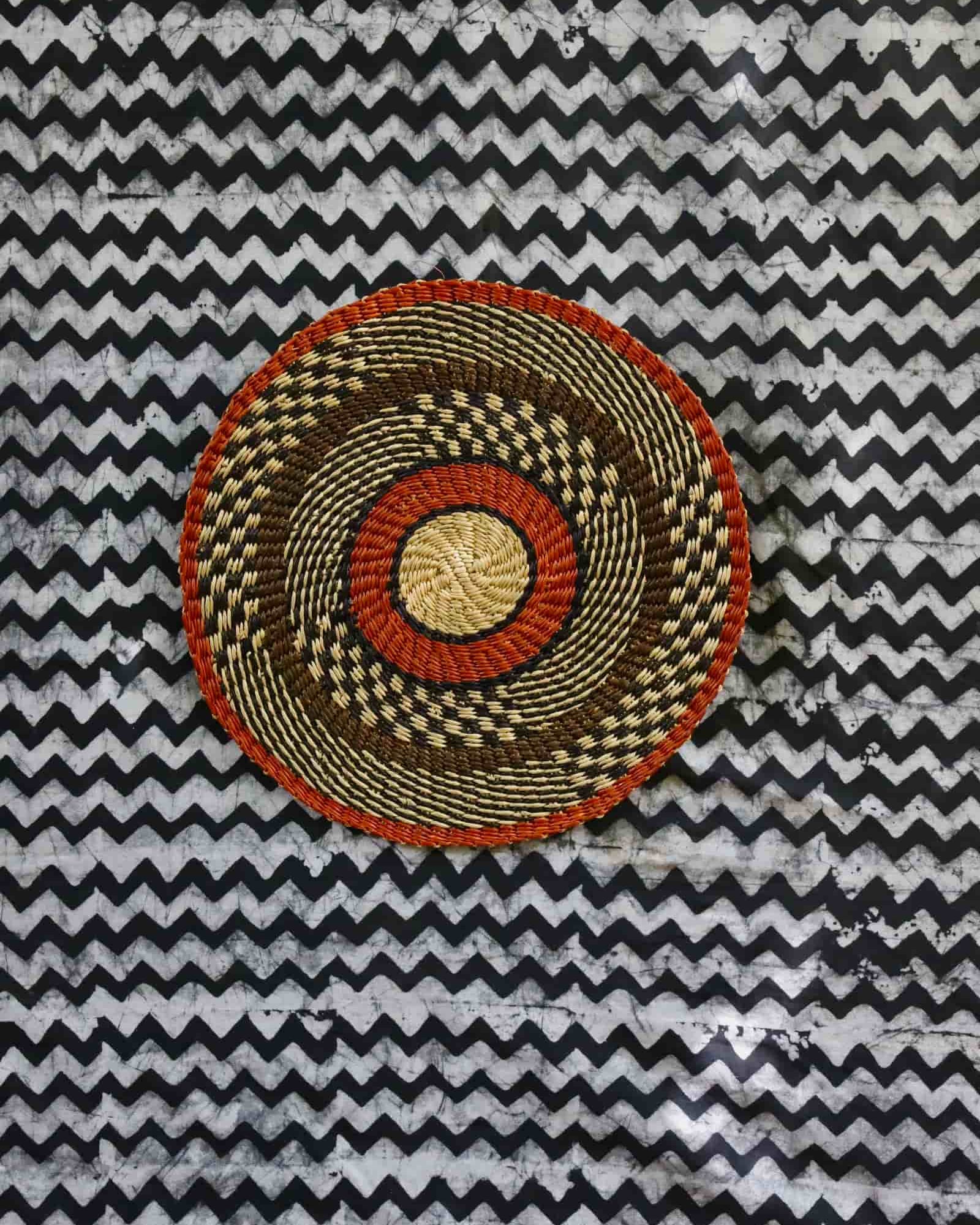 Large woven placemat with terracotta outer rim, black and natural checkered mid-band