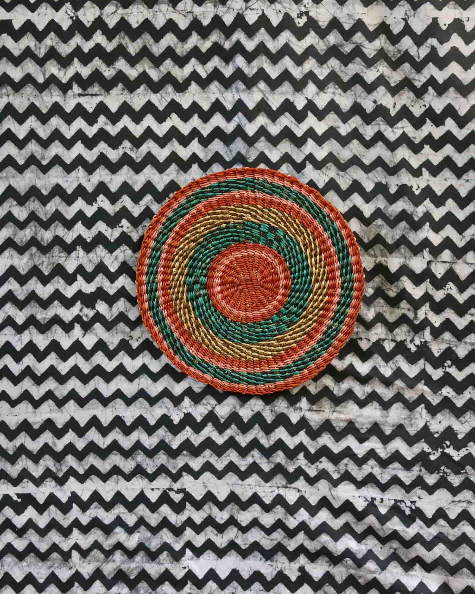 Small woven placemat with terracotta centre, teal ring and gold outer band