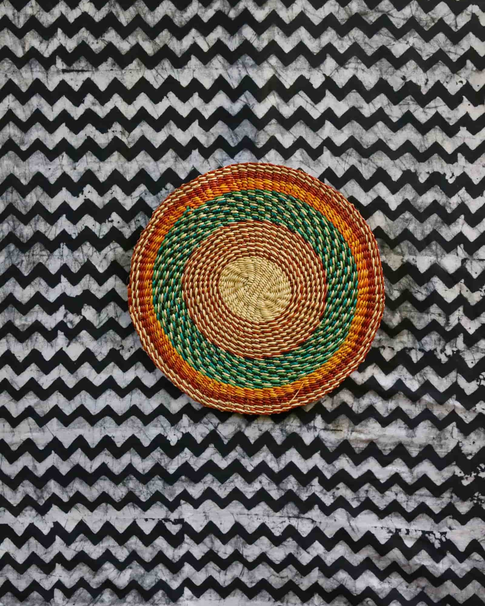 Small woven placemat set of 4 — green and orange concentric rings on natural straw