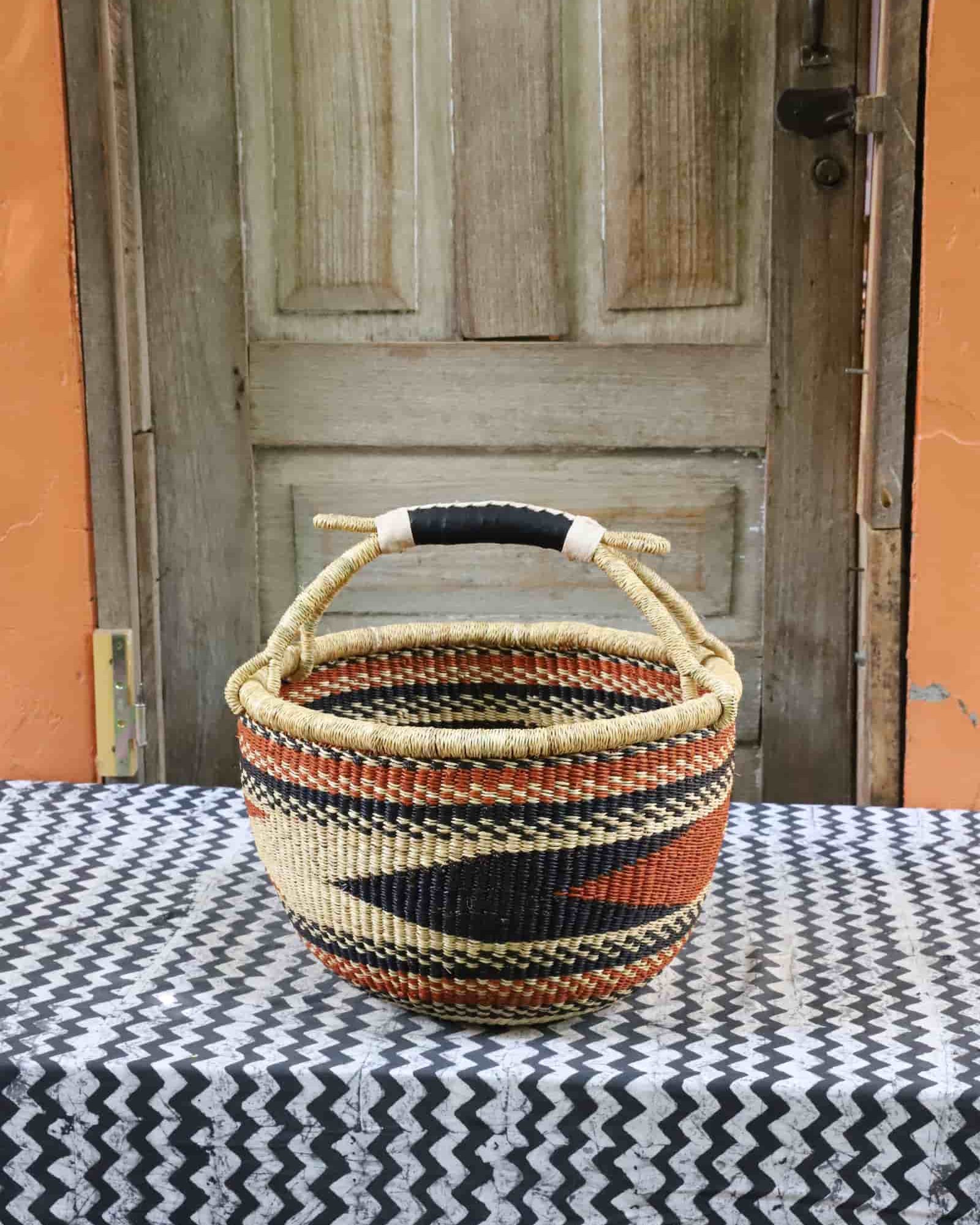 Large round Bolga basket in black, natural and terracotta diagonal zigzag with a black leather handle