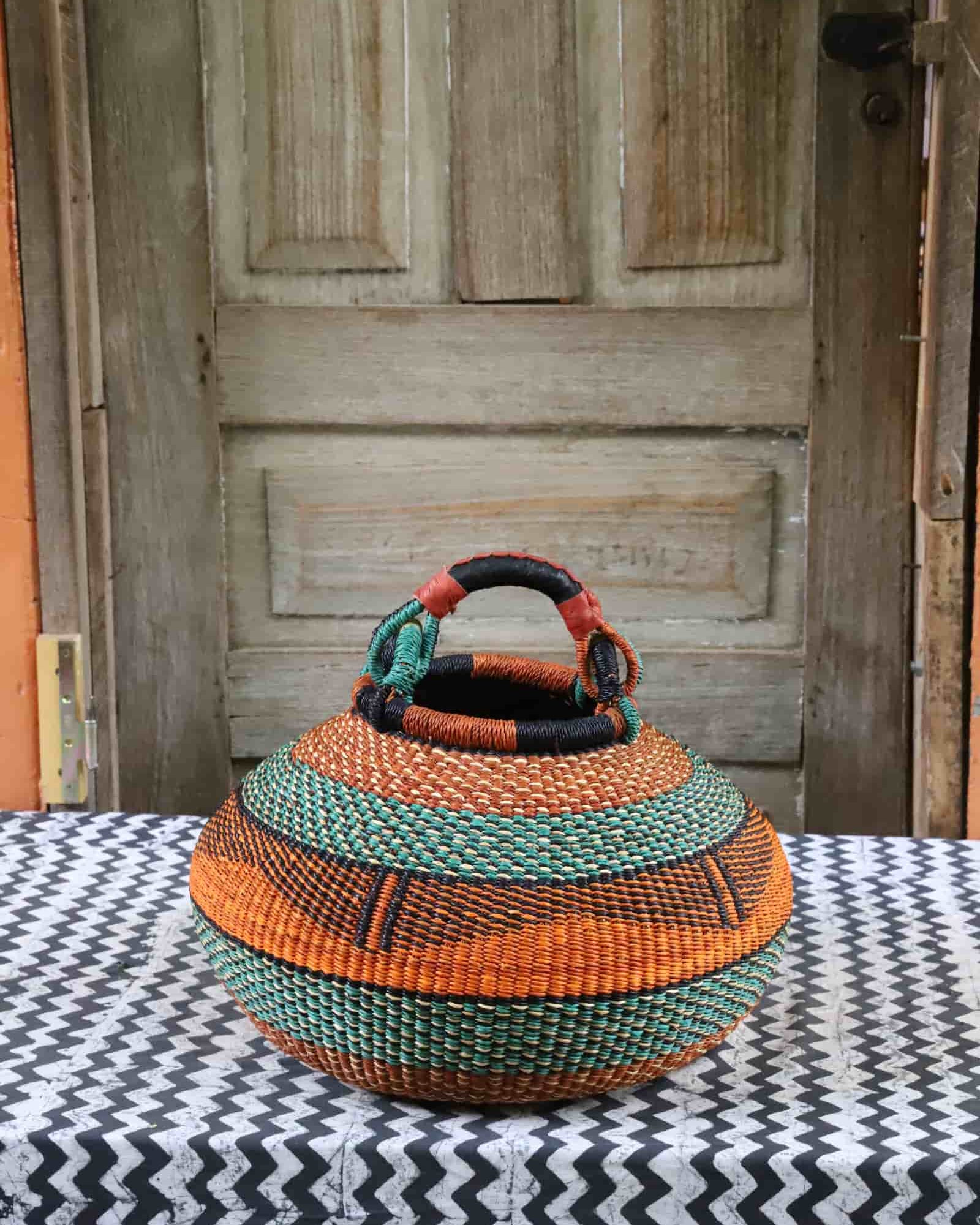 Large pot storage basket in burnt orange and teal bands with black geometric detail