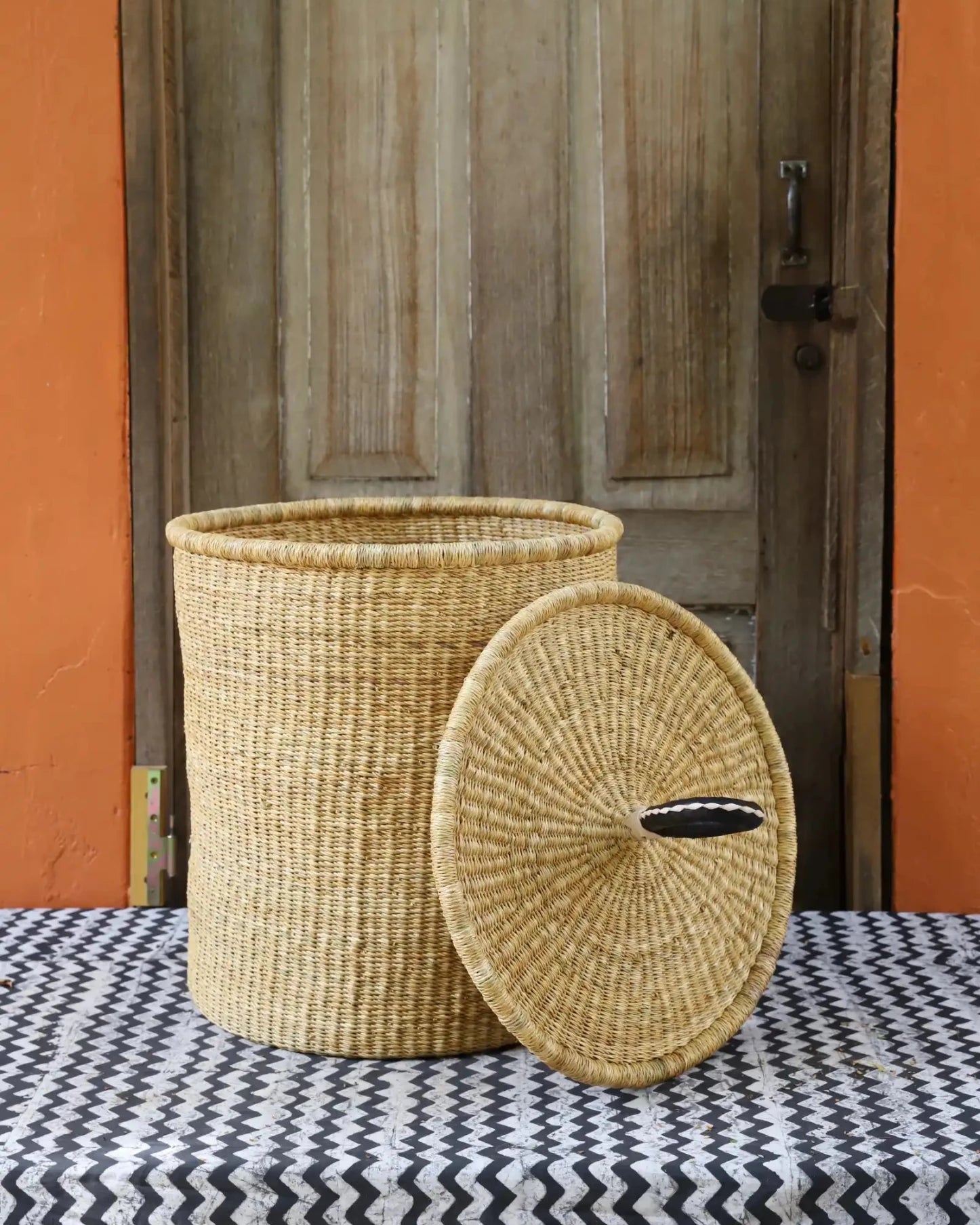 Lidded Laundry Basket with coil (Medium) by The Baba Tree. Handwoven elephant grass with leather handle. Premium Bolgatanga artisan decor.