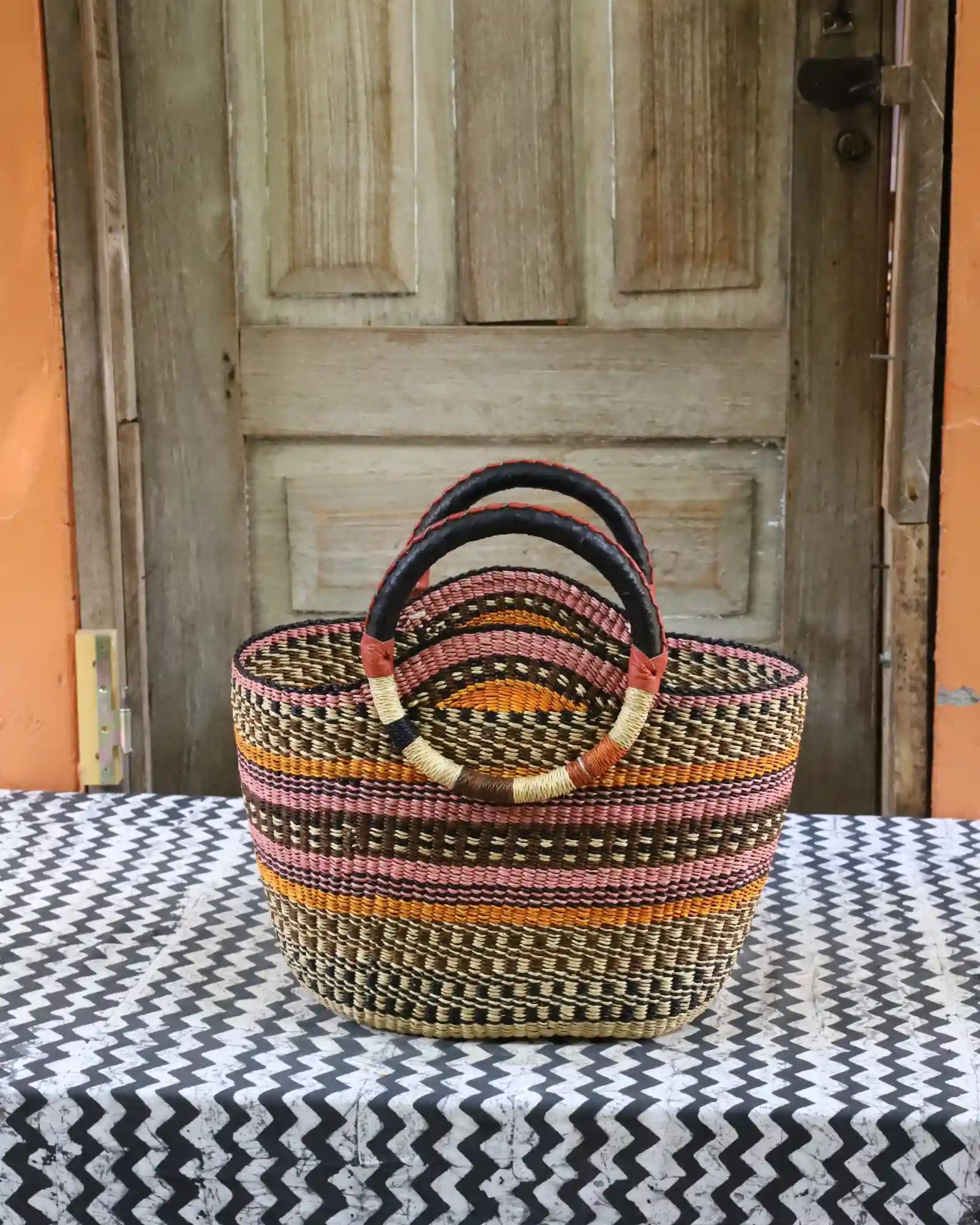 Naughty George weekend bag: dark stripe body in black, pink and orange with leather handles