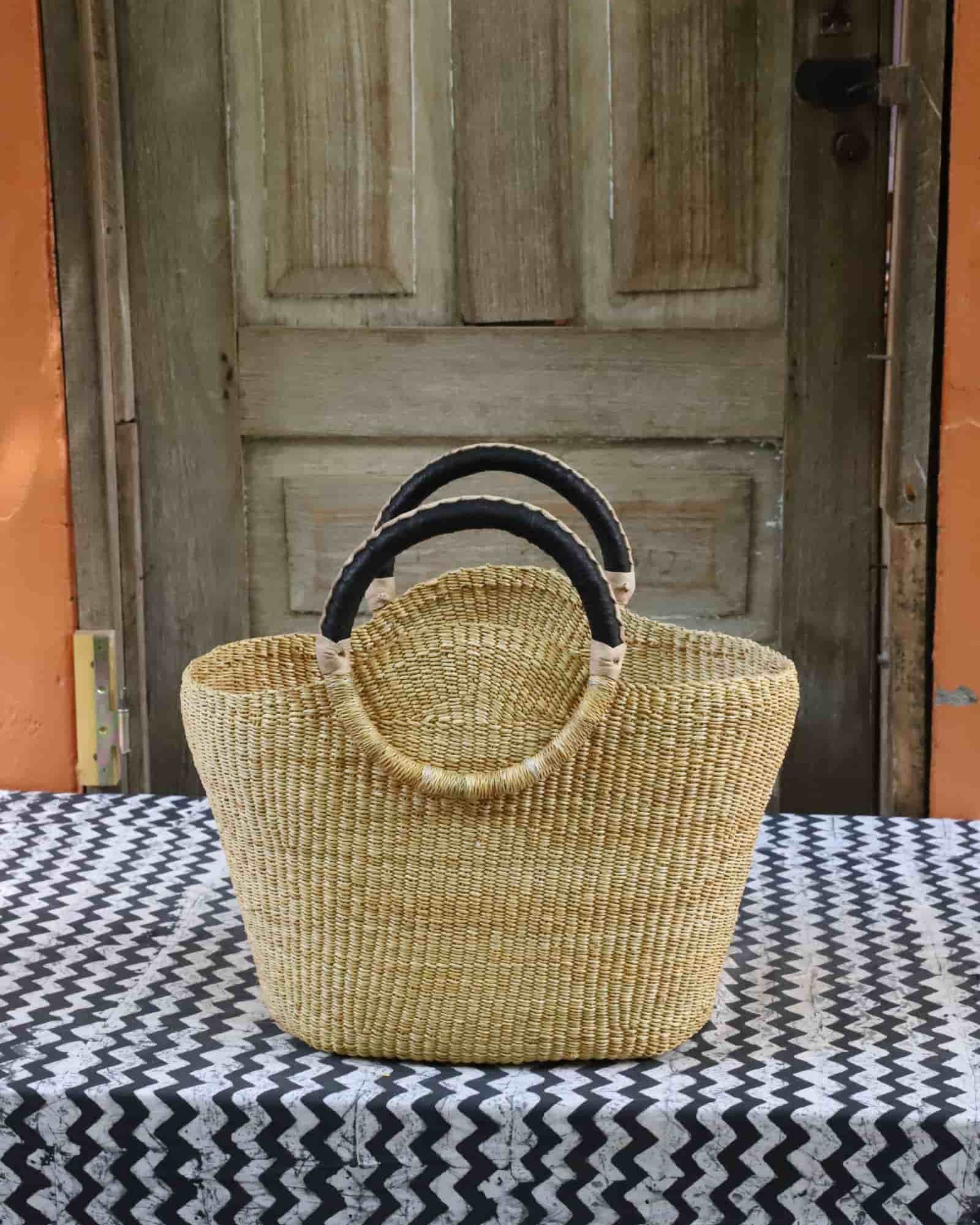 Naughty George weekend bag in natural straw with black leather loop handles, front view