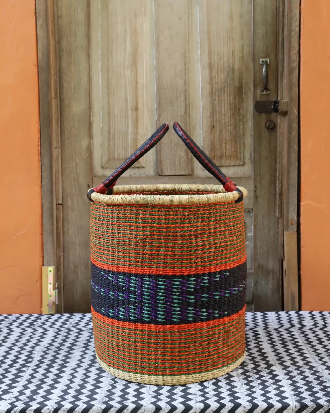 Open Laundry Basket (Small) by The Baba Tree. Handwoven elephant grass storage with leather handles. Bolgatanga artisan decor.