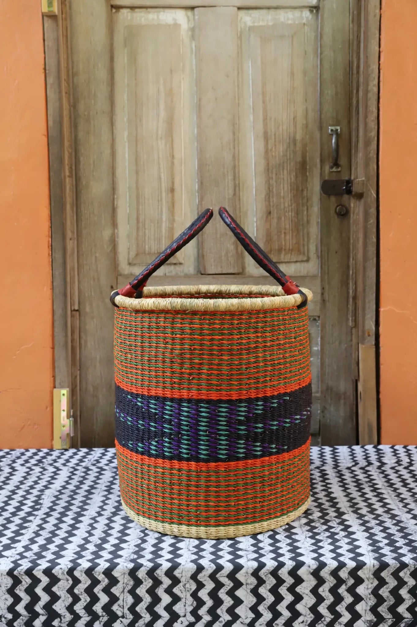 Open Laundry Basket (Small) by The Baba Tree. Handwoven elephant grass storage with leather handles. Bolgatanga artisan decor.