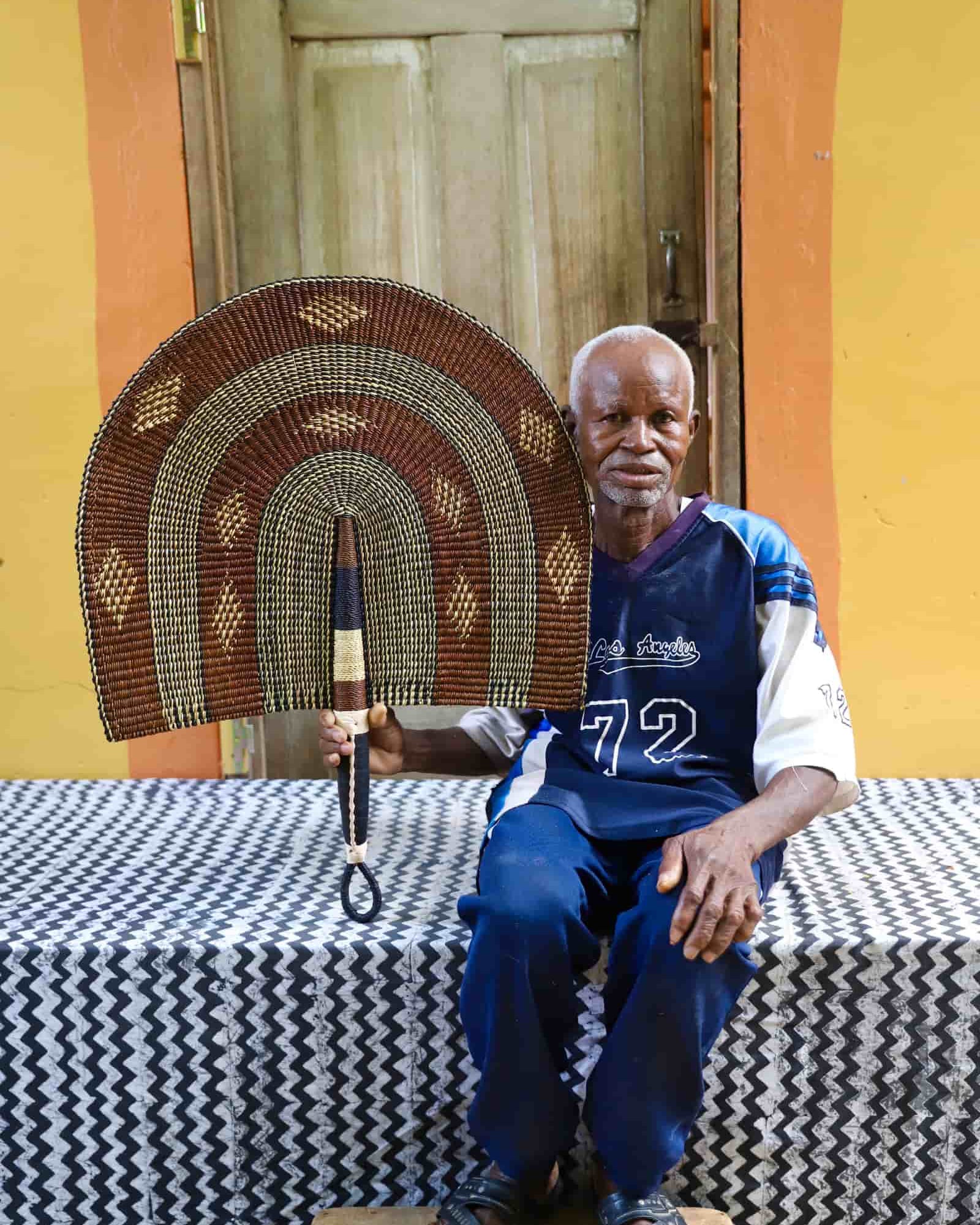Man holding Naba Penga wall décor in brown and cream with diamond motifs