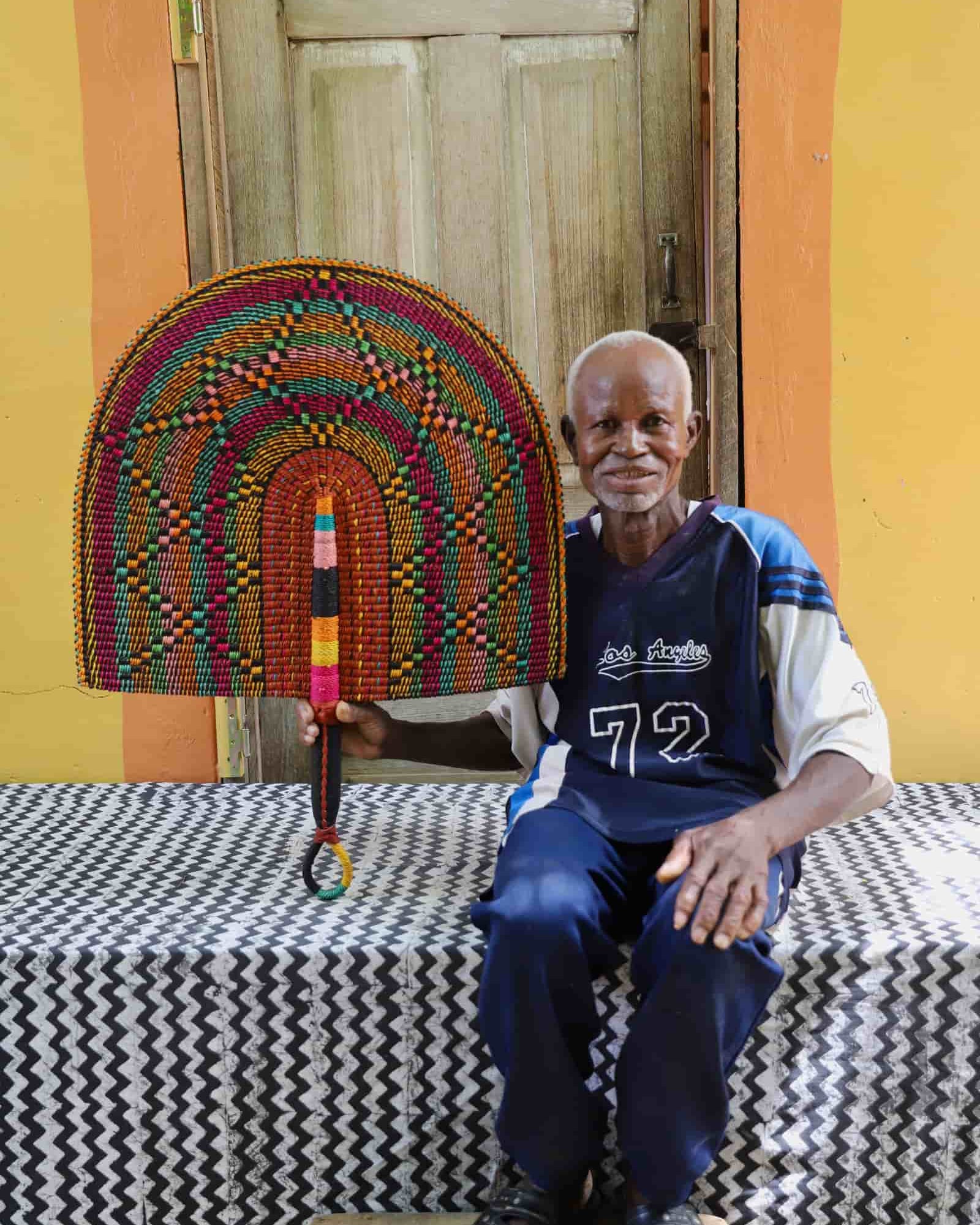 Man holding Naba Penga rainbow arch wall décor with multicolour spot pattern