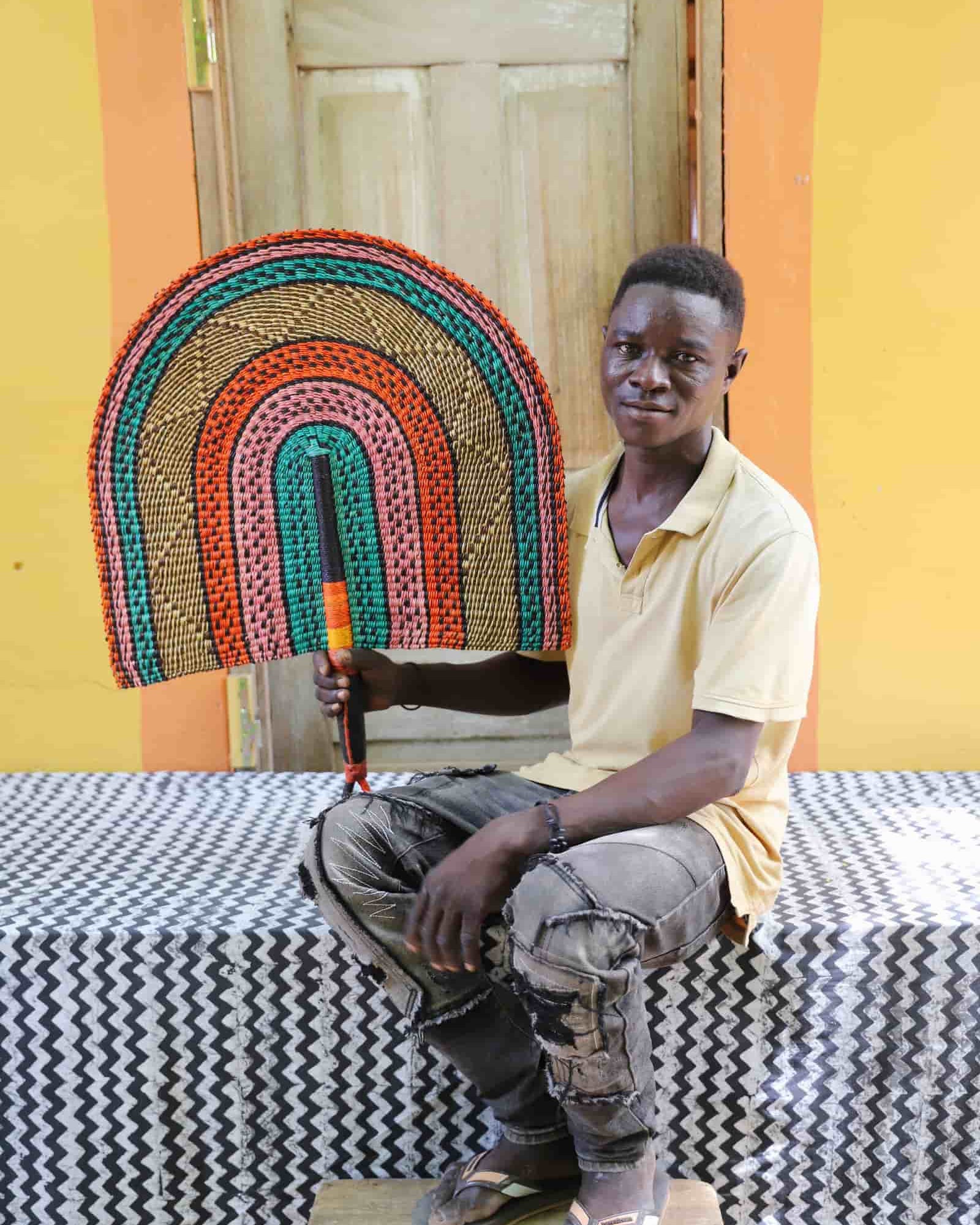Man holding Naba Penga rainbow arch wall décor in teal, terracotta and pink