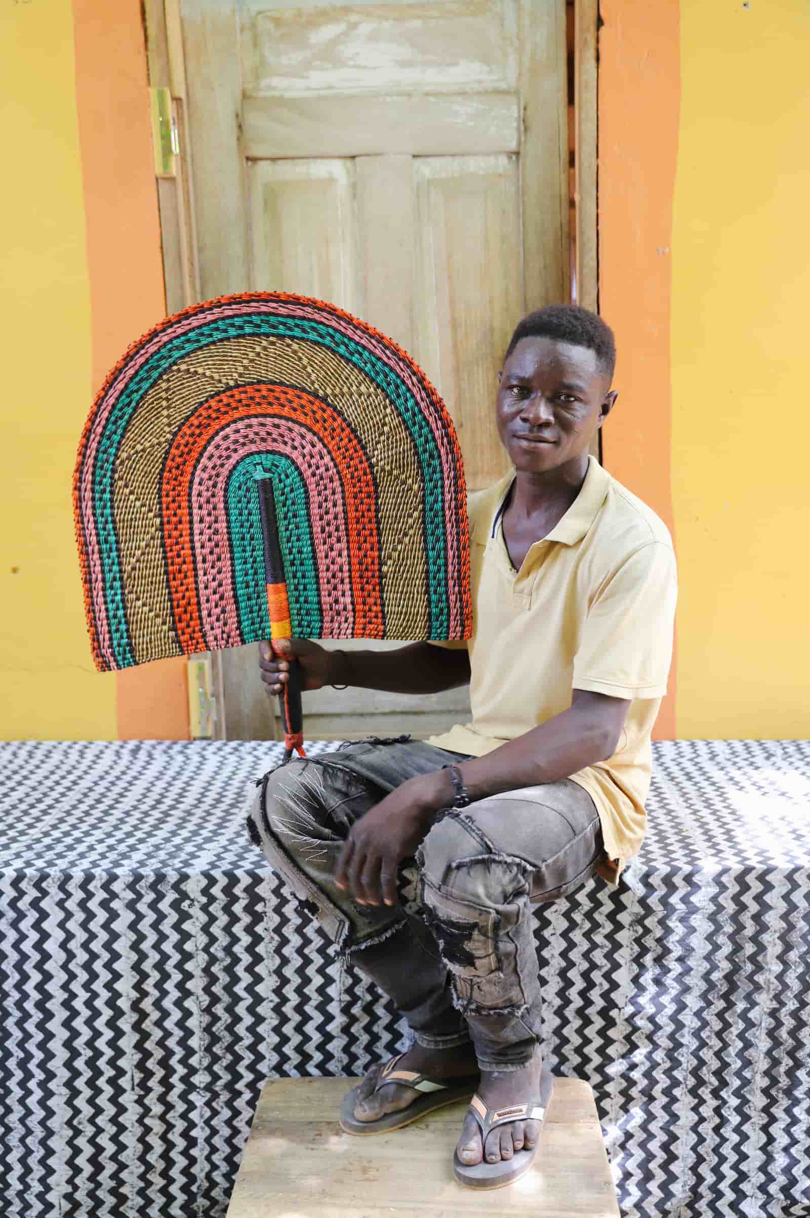 Man holding Naba Penga rainbow arch wall décor in teal, terracotta and pink