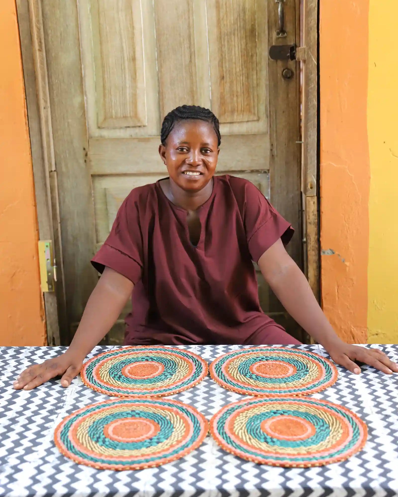 Set of 4 small placemats showing terracotta and teal concentric weave pattern