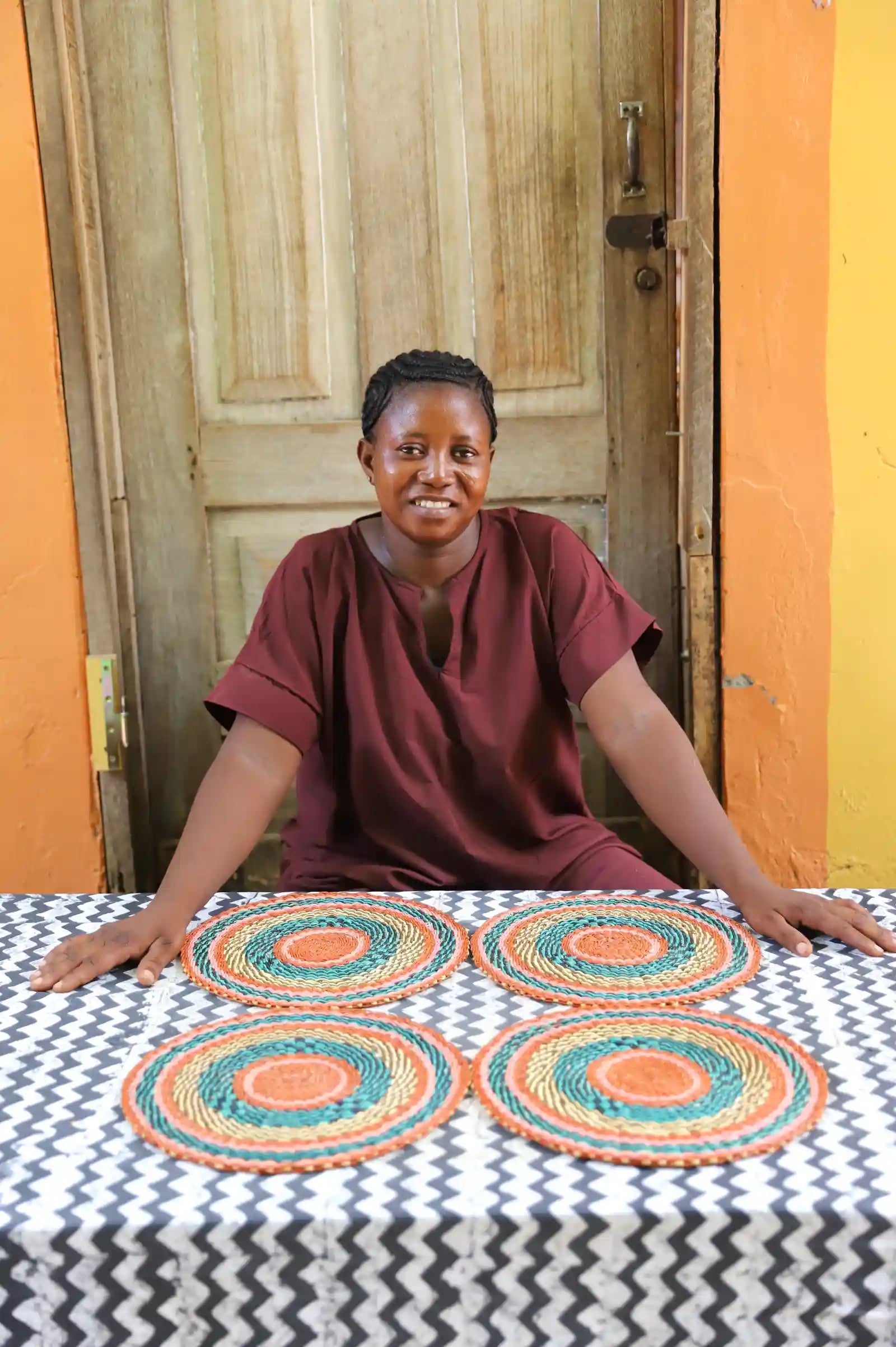 Set of 4 small placemats showing terracotta and teal concentric weave pattern