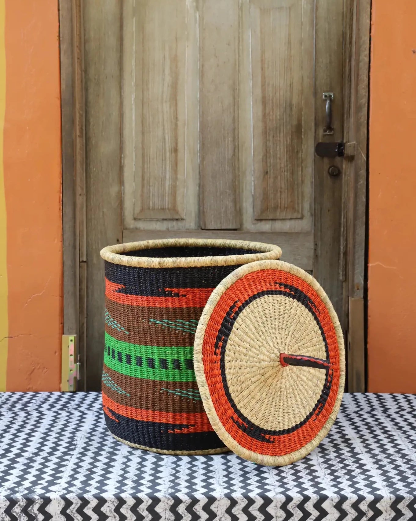 Lidded Laundry Basket with coil (Small) by The Baba Tree. Handwoven elephant grass with leather handle. Premium Bolgatanga artisan decor.