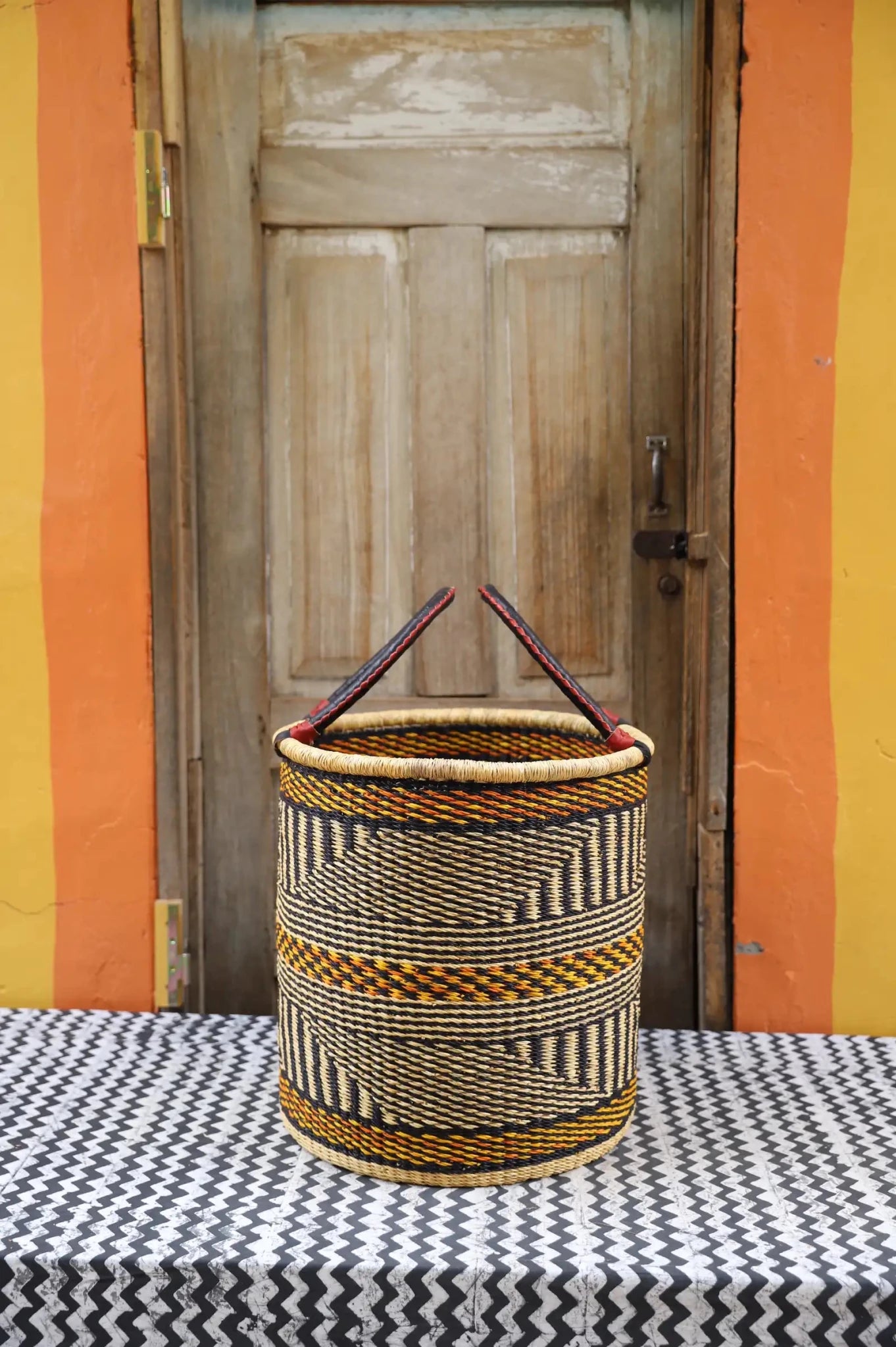 Open Laundry Basket (Medium) by The Baba Tree. Handwoven elephant grass storage with leather handles. Bolgatanga artisan decor.