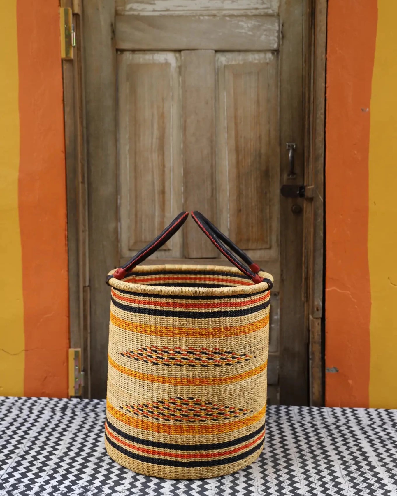 Open Laundry Basket (Medium) by The Baba Tree. Handwoven elephant grass storage with leather handles. Bolgatanga artisan decor.