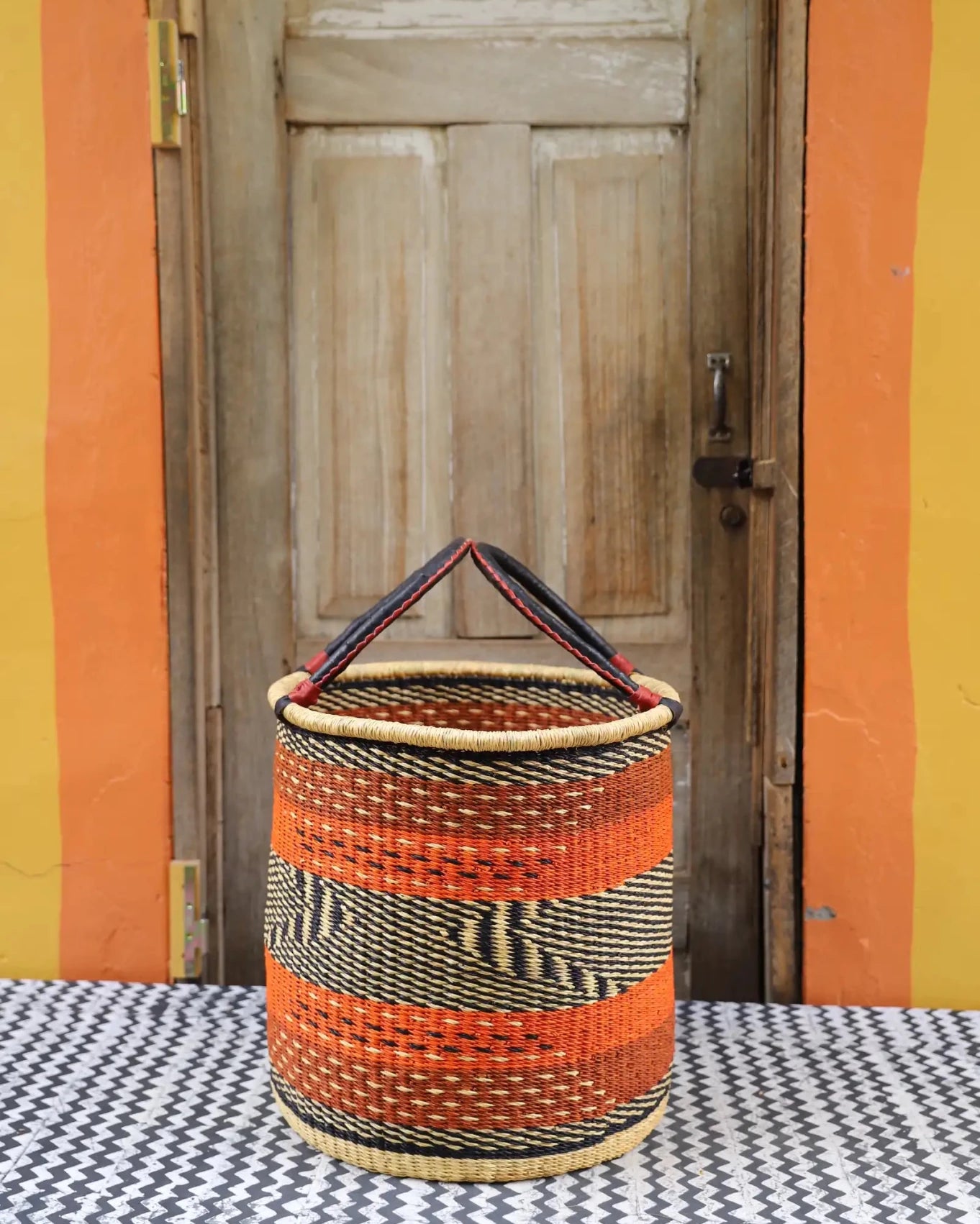 Open Laundry Basket (Medium) by The Baba Tree. Handwoven elephant grass storage with leather handles. Bolgatanga artisan decor.