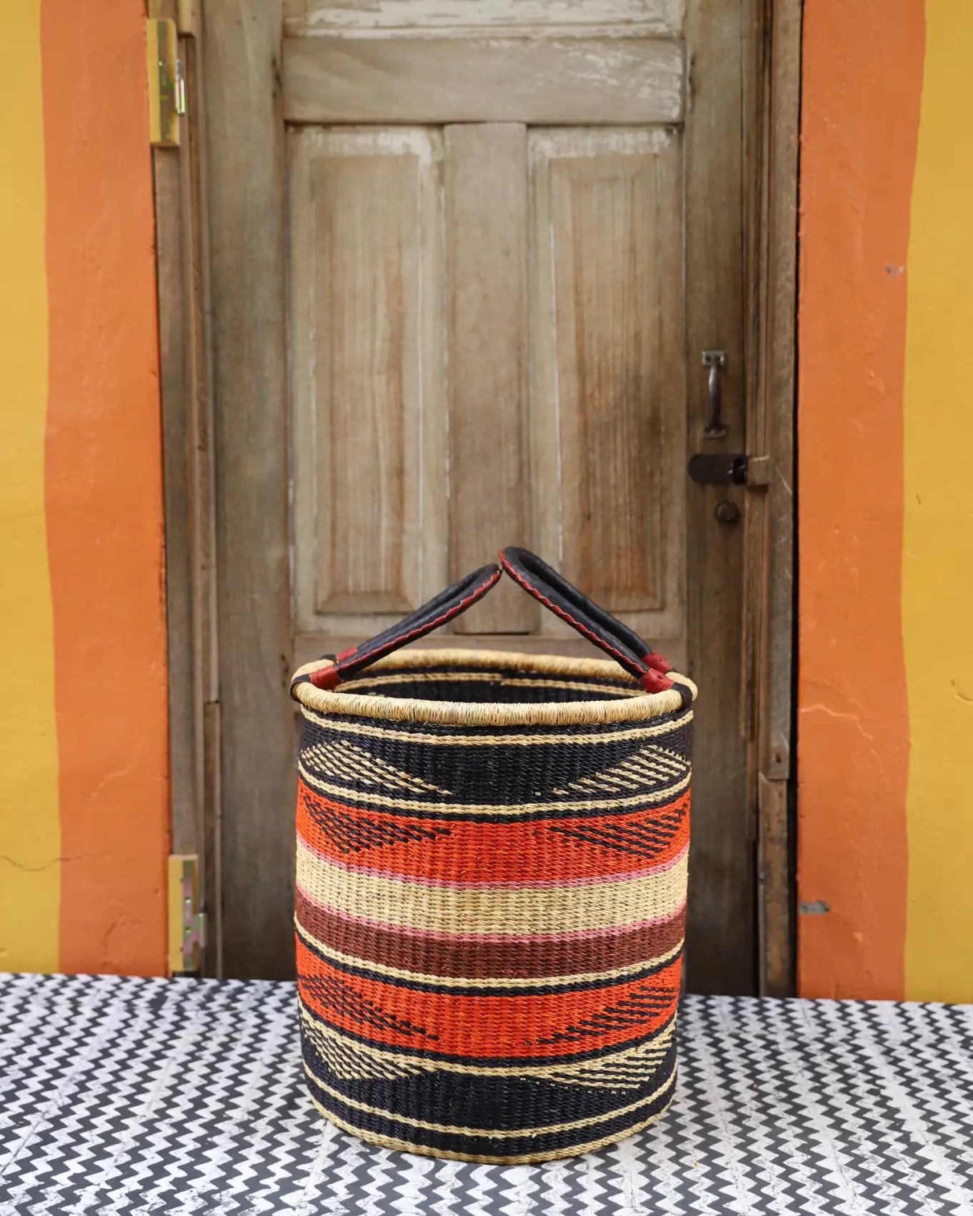 Open Laundry Basket (Medium) by The Baba Tree. Handwoven elephant grass storage with leather handles. Bolgatanga artisan decor.