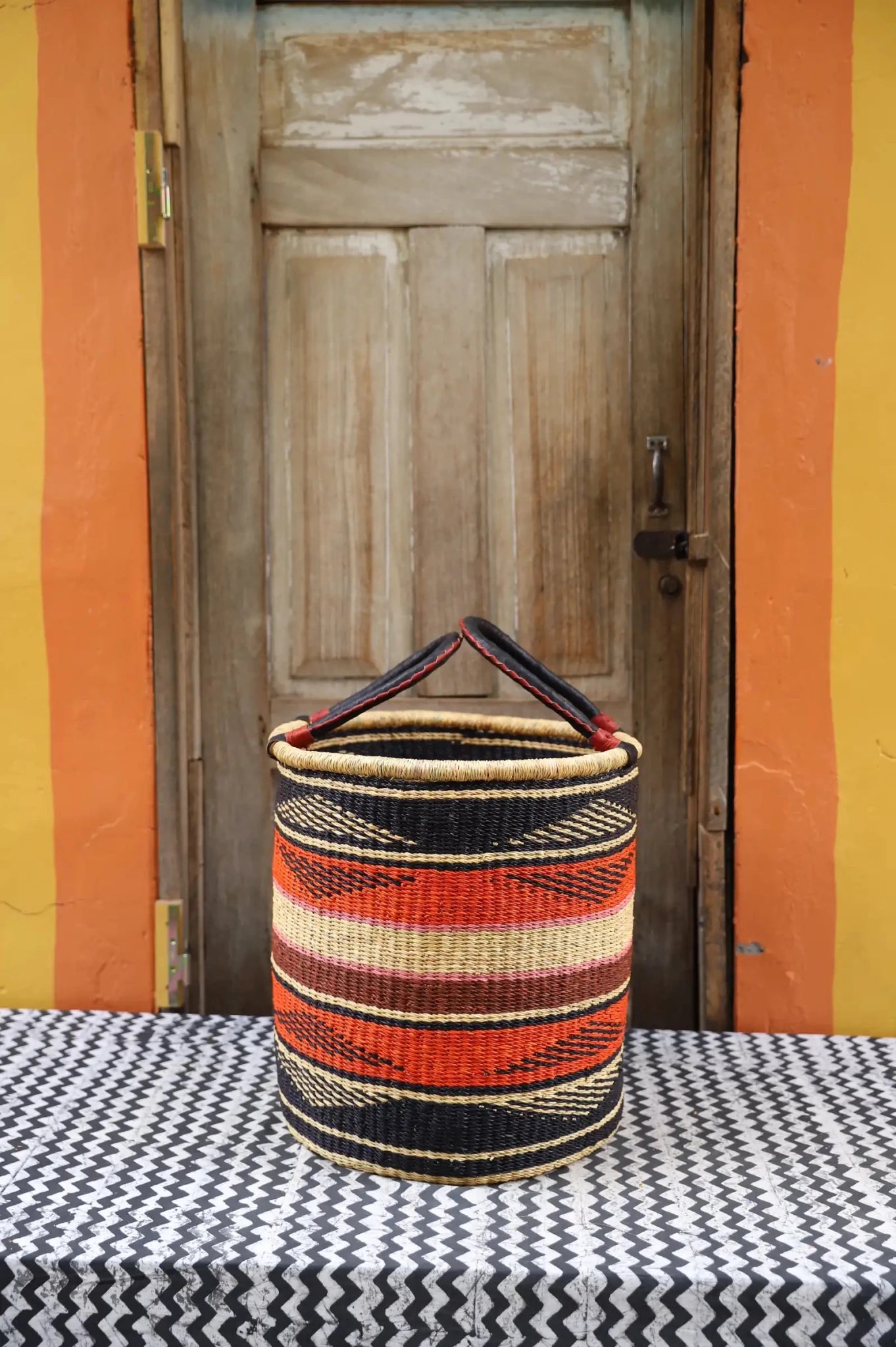 Open Laundry Basket (Medium) by The Baba Tree. Handwoven elephant grass storage with leather handles. Bolgatanga artisan decor.