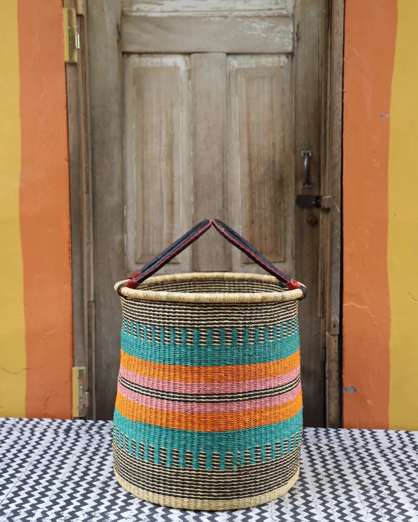 Open Laundry Basket (Large) by The Baba Tree. Handwoven elephant grass storage with leather handles. Bolgatanga artisan decor.