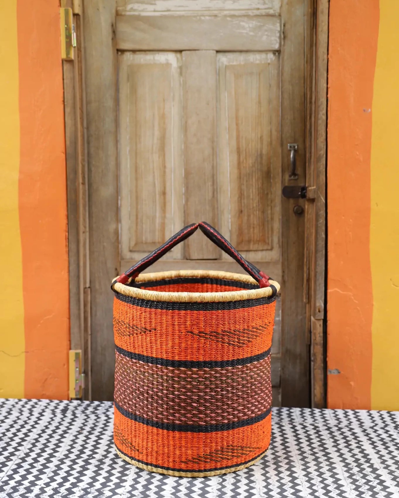 Open Laundry Basket (Medium) by The Baba Tree. Handwoven elephant grass storage with leather handles. Bolgatanga artisan decor.
