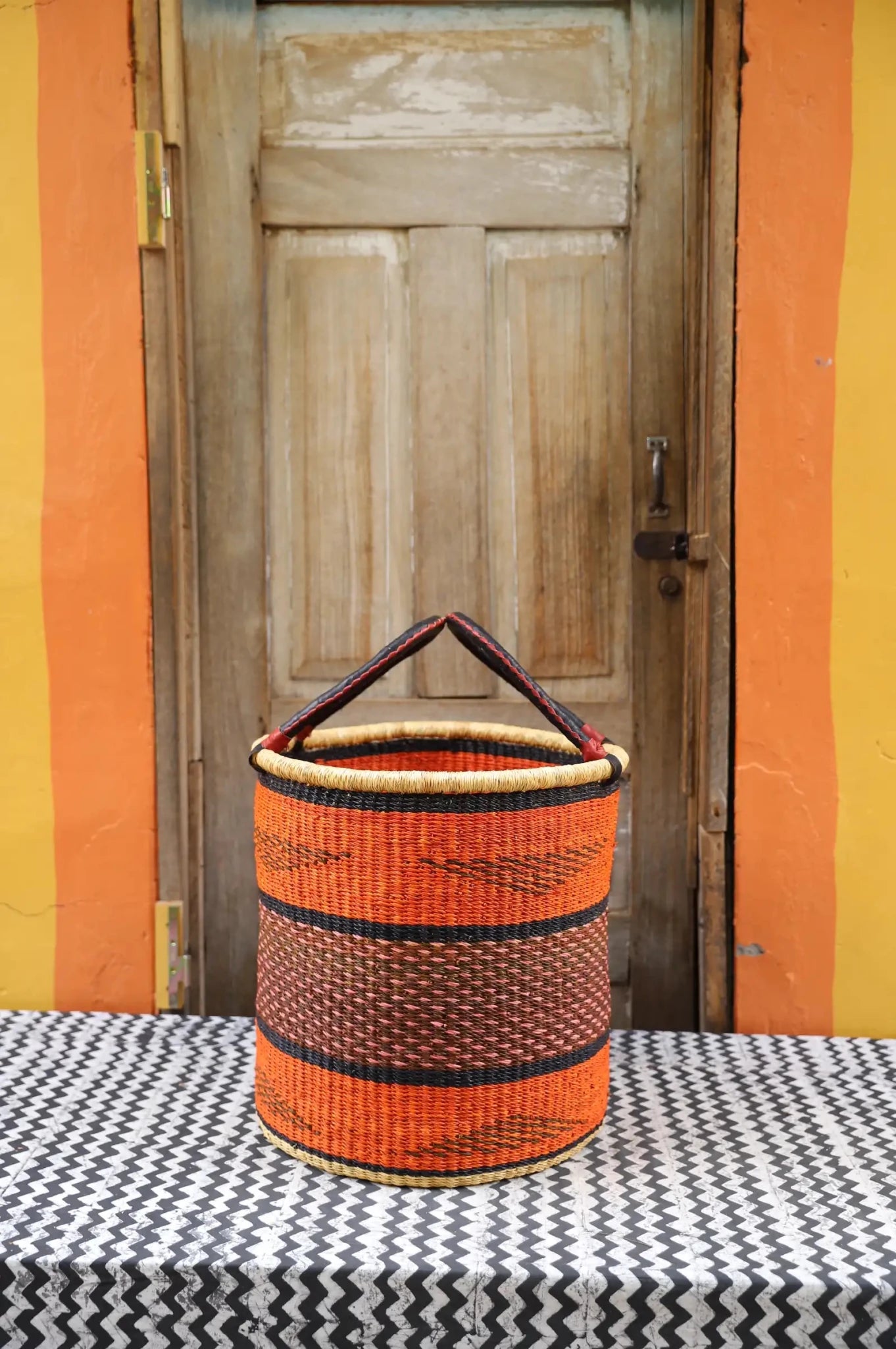 Open Laundry Basket (Medium) by The Baba Tree. Handwoven elephant grass storage with leather handles. Bolgatanga artisan decor.