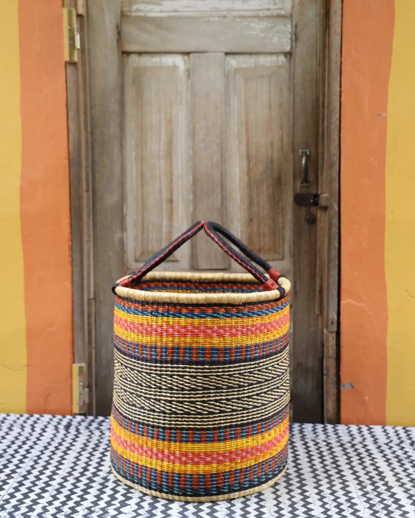 Open Laundry Basket (Large) by The Baba Tree. Handwoven elephant grass storage with leather handles. Bolgatanga artisan decor.