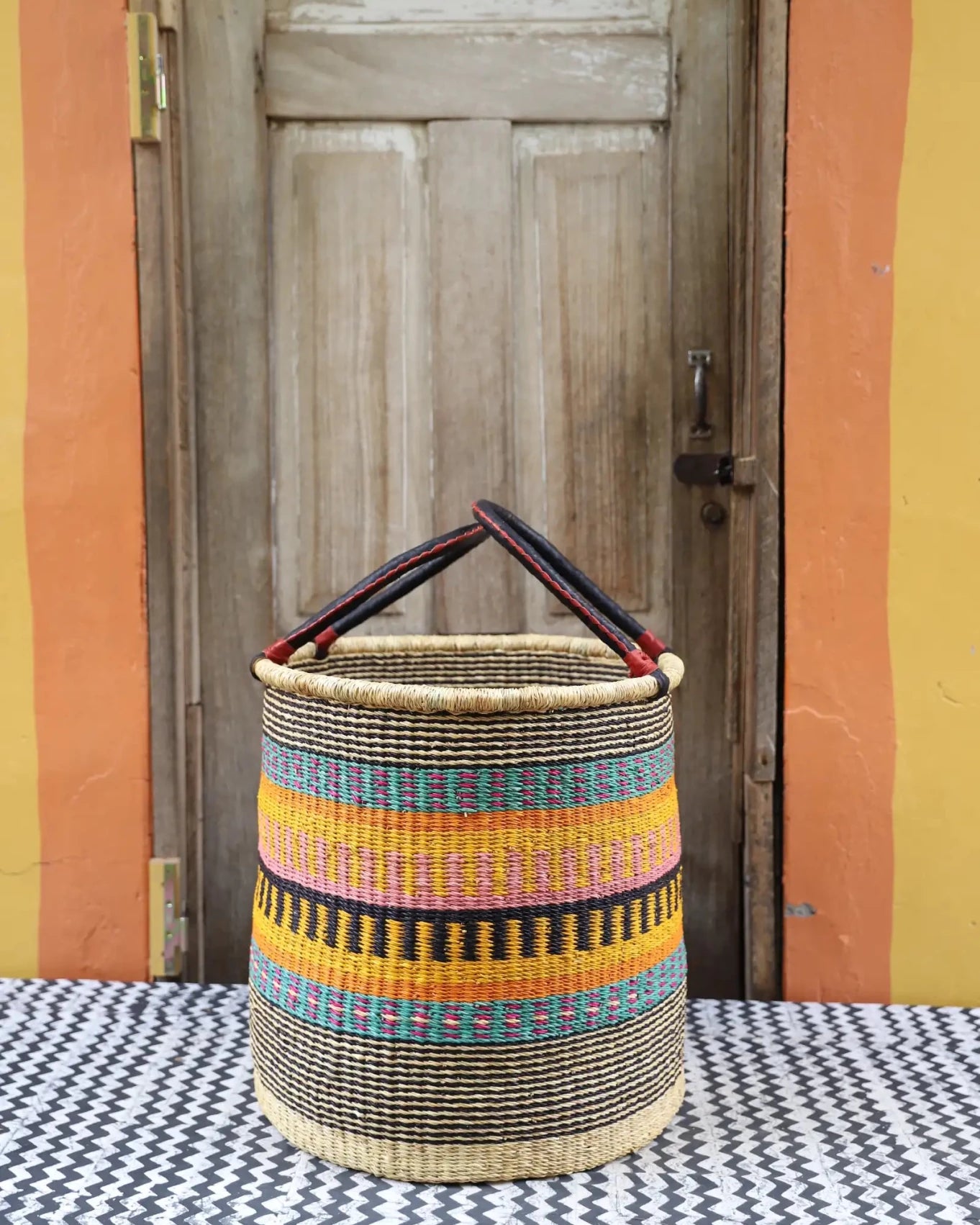 Open Laundry Basket (Large) by The Baba Tree. Handwoven elephant grass storage with leather handles. Bolgatanga artisan decor.