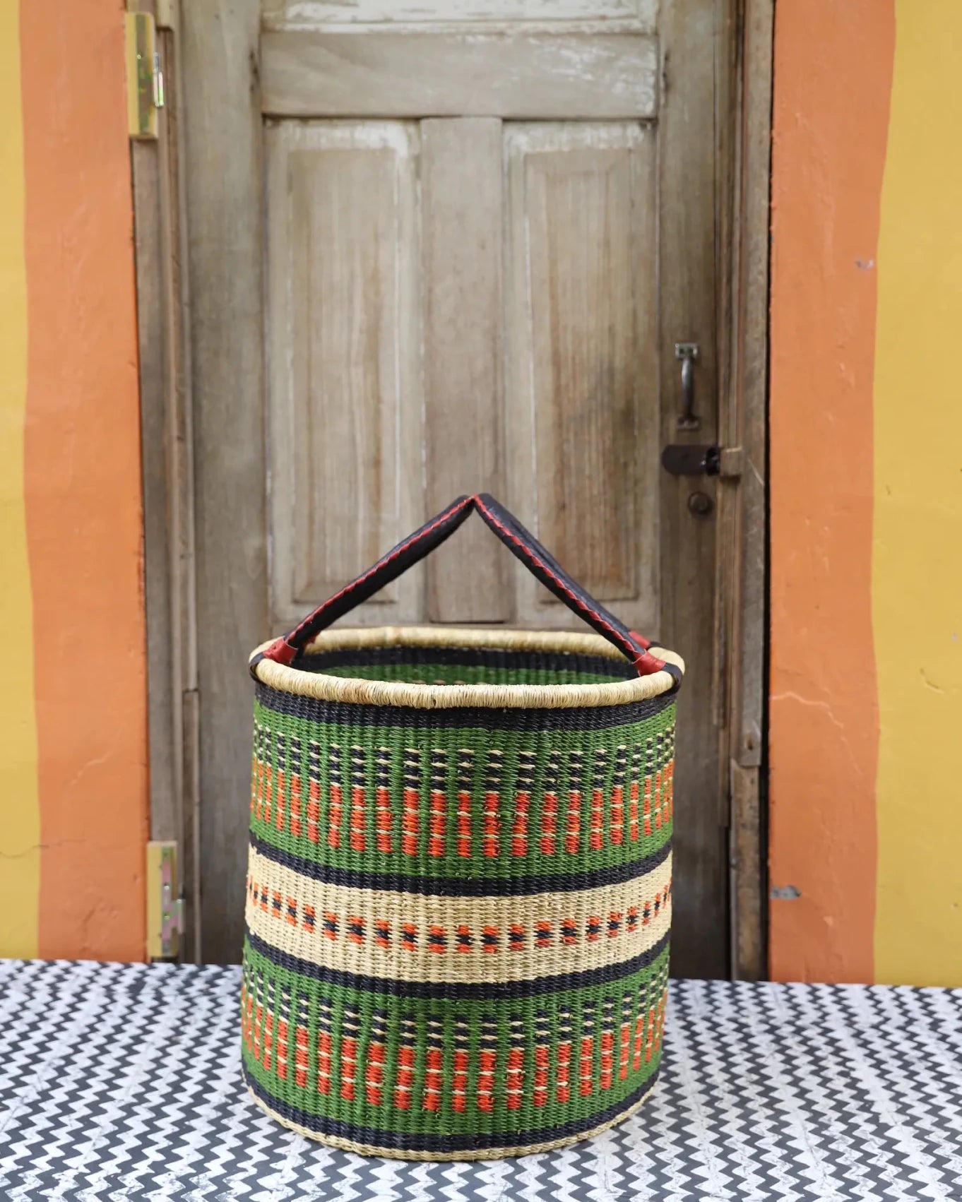 Open Laundry Basket (Large) by The Baba Tree. Handwoven elephant grass storage with leather handles. Bolgatanga artisan decor.