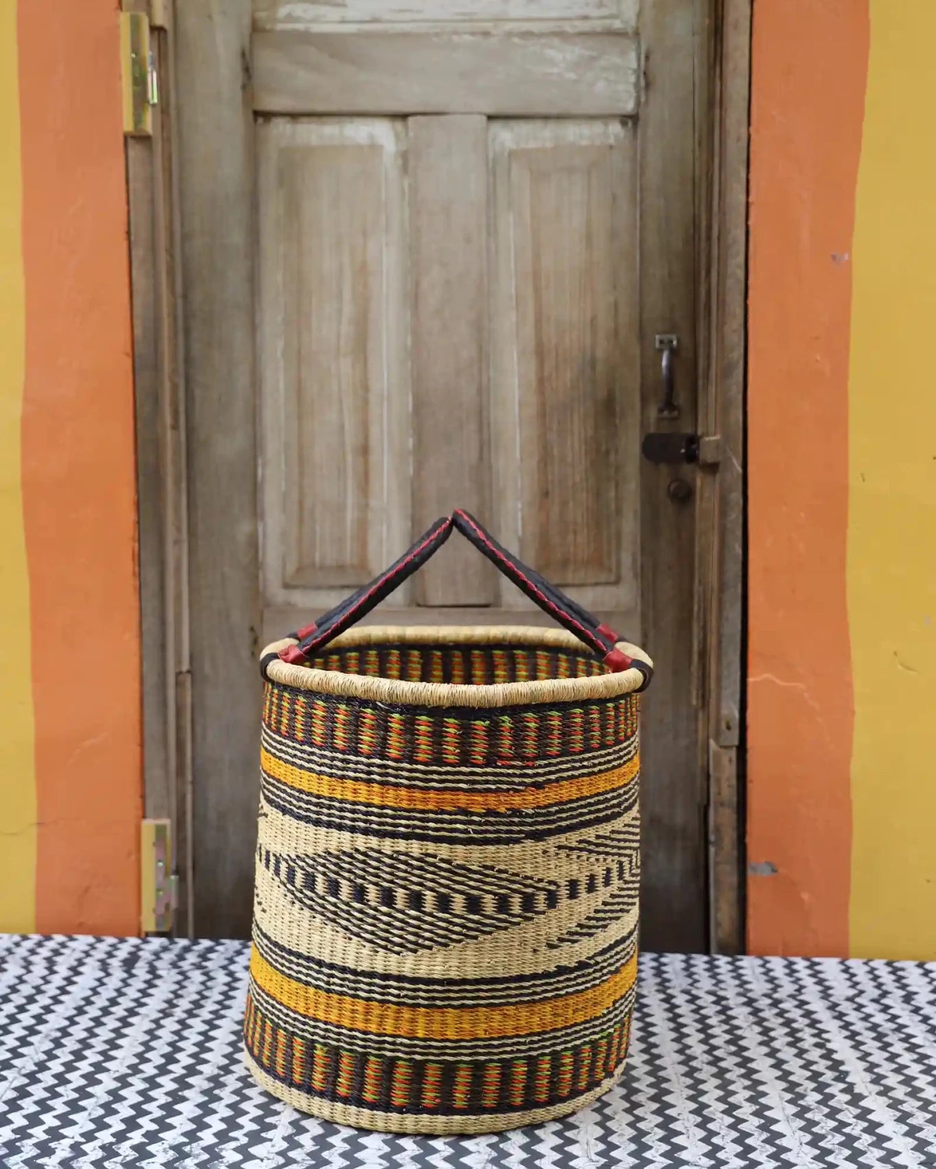 Open Laundry Basket (Medium) by The Baba Tree. Handwoven elephant grass storage with leather handles. Bolgatanga artisan decor.