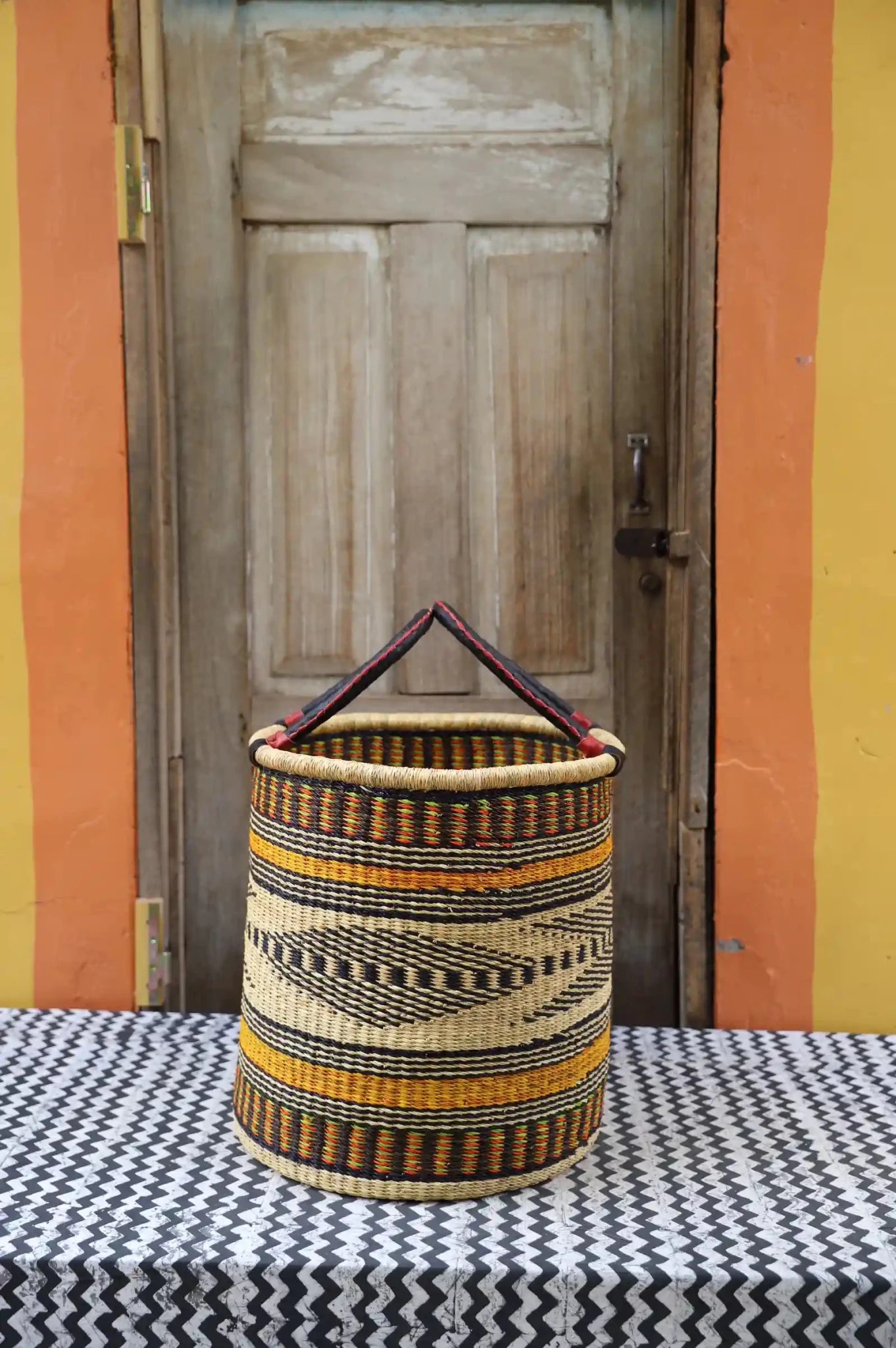 Open Laundry Basket (Medium) by The Baba Tree. Handwoven elephant grass storage with leather handles. Bolgatanga artisan decor.