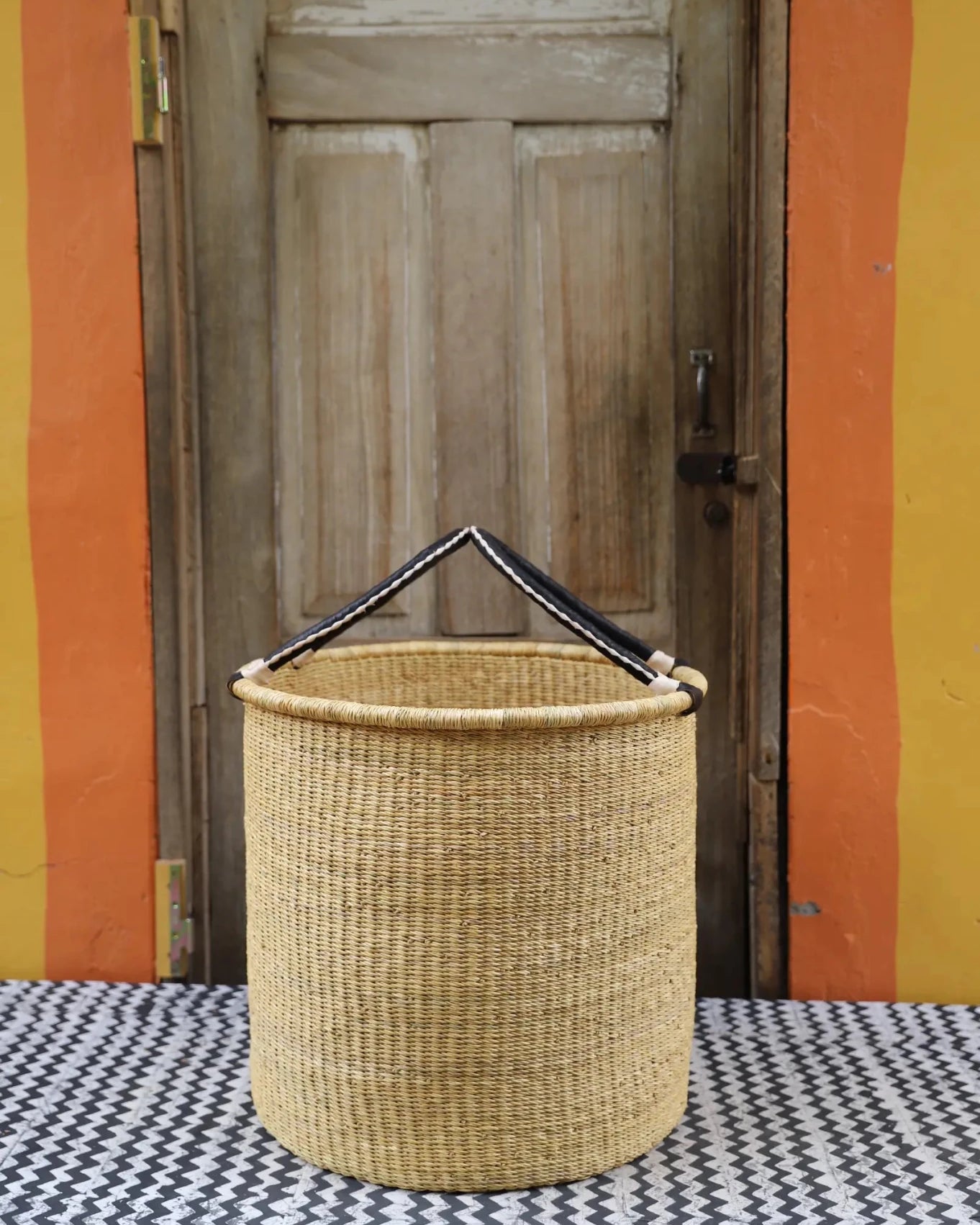 Open Laundry Basket (Large) by The Baba Tree. Handwoven elephant grass storage with leather handles. Bolgatanga artisan decor.