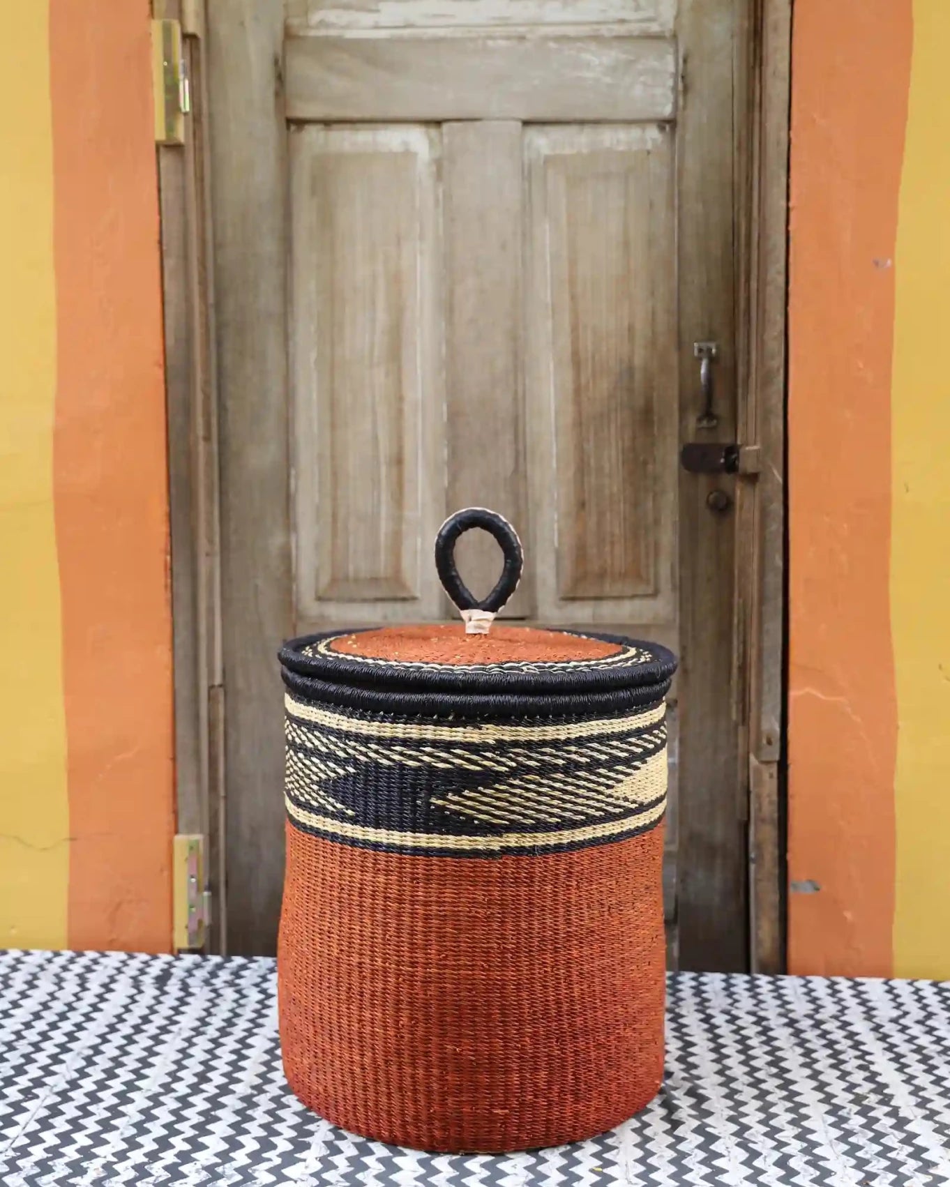 Lidded Laundry Basket with coil (Medium) by The Baba Tree. Handwoven elephant grass with leather handle. Premium Bolgatanga artisan decor.