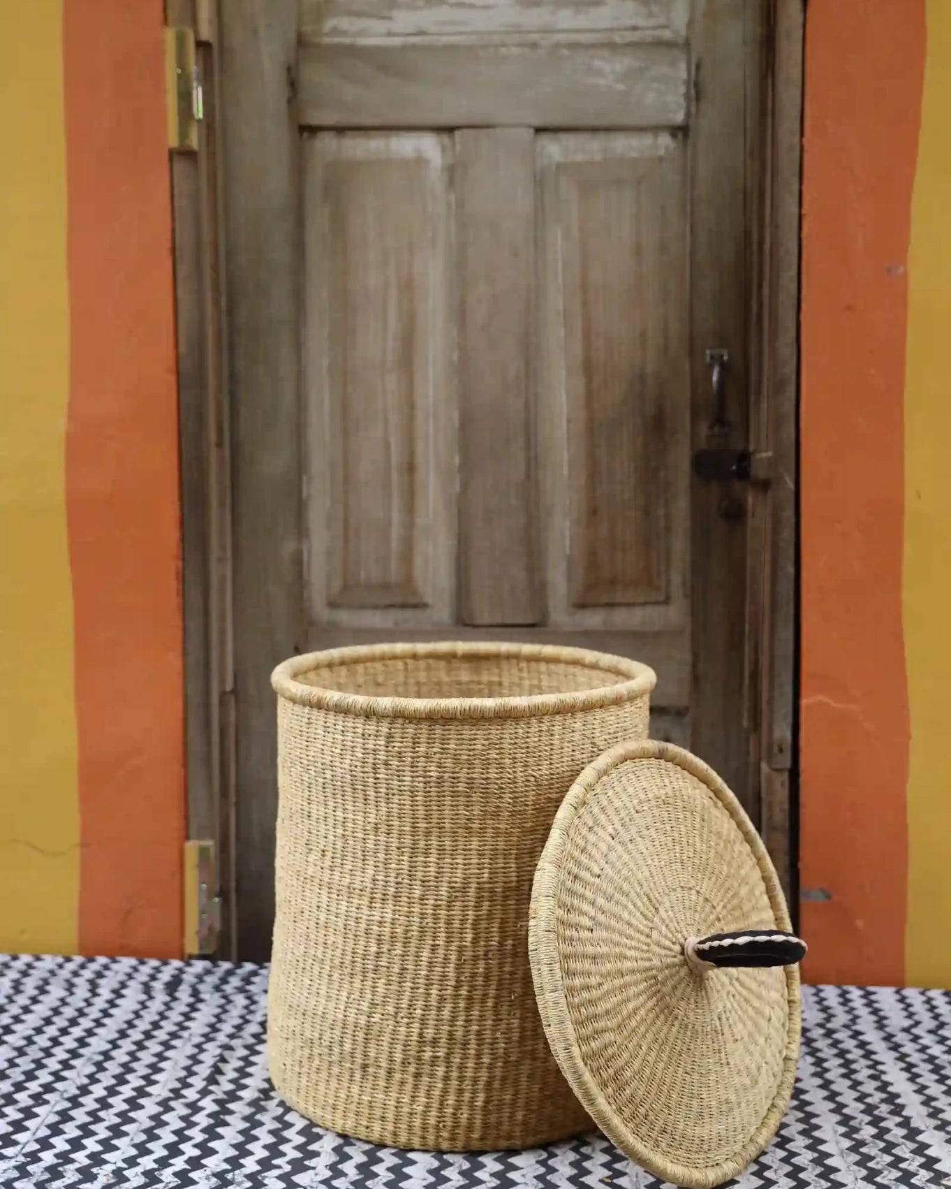 Lidded Laundry Basket with coil (Medium) by The Baba Tree. Handwoven elephant grass with leather handle. Premium Bolgatanga artisan decor.
