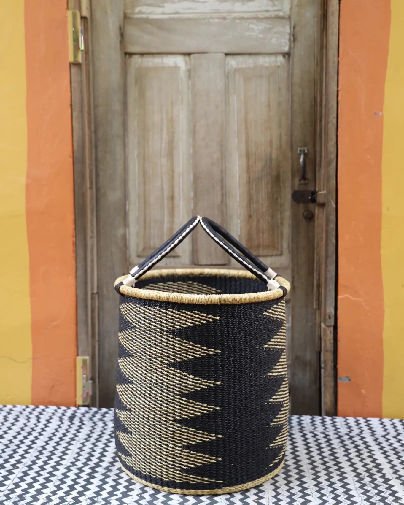 Open Laundry Basket (Medium) by The Baba Tree. Handwoven elephant grass storage with leather handles. Bolgatanga artisan decor.