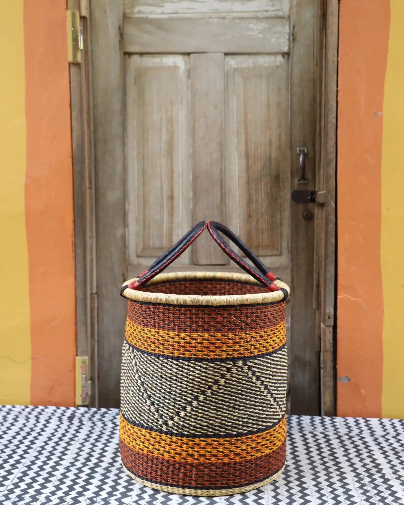 Open Laundry Basket (Medium) by The Baba Tree. Handwoven elephant grass storage with leather handles. Bolgatanga artisan decor.