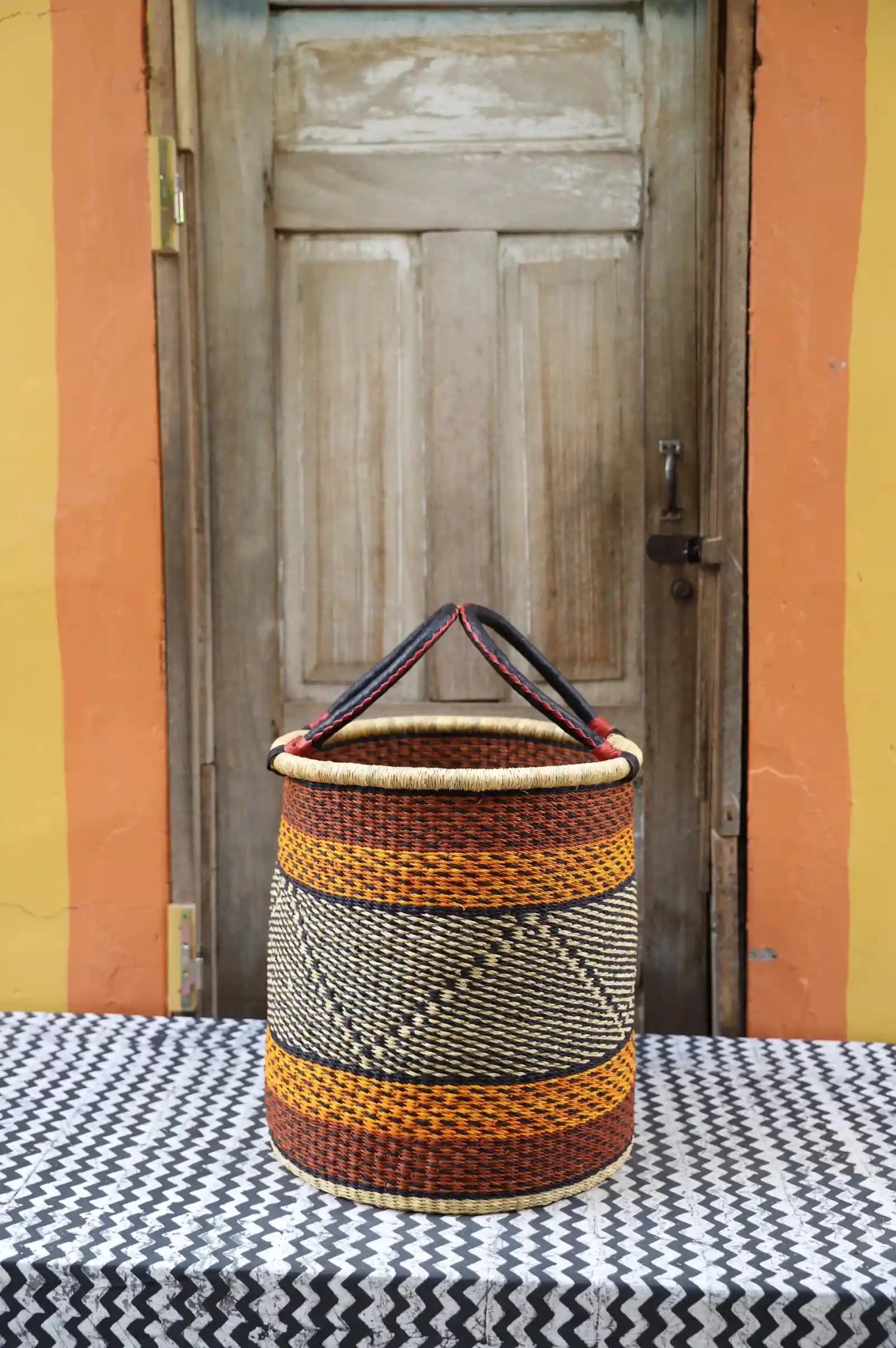 Open Laundry Basket (Medium) by The Baba Tree. Handwoven elephant grass storage with leather handles. Bolgatanga artisan decor.