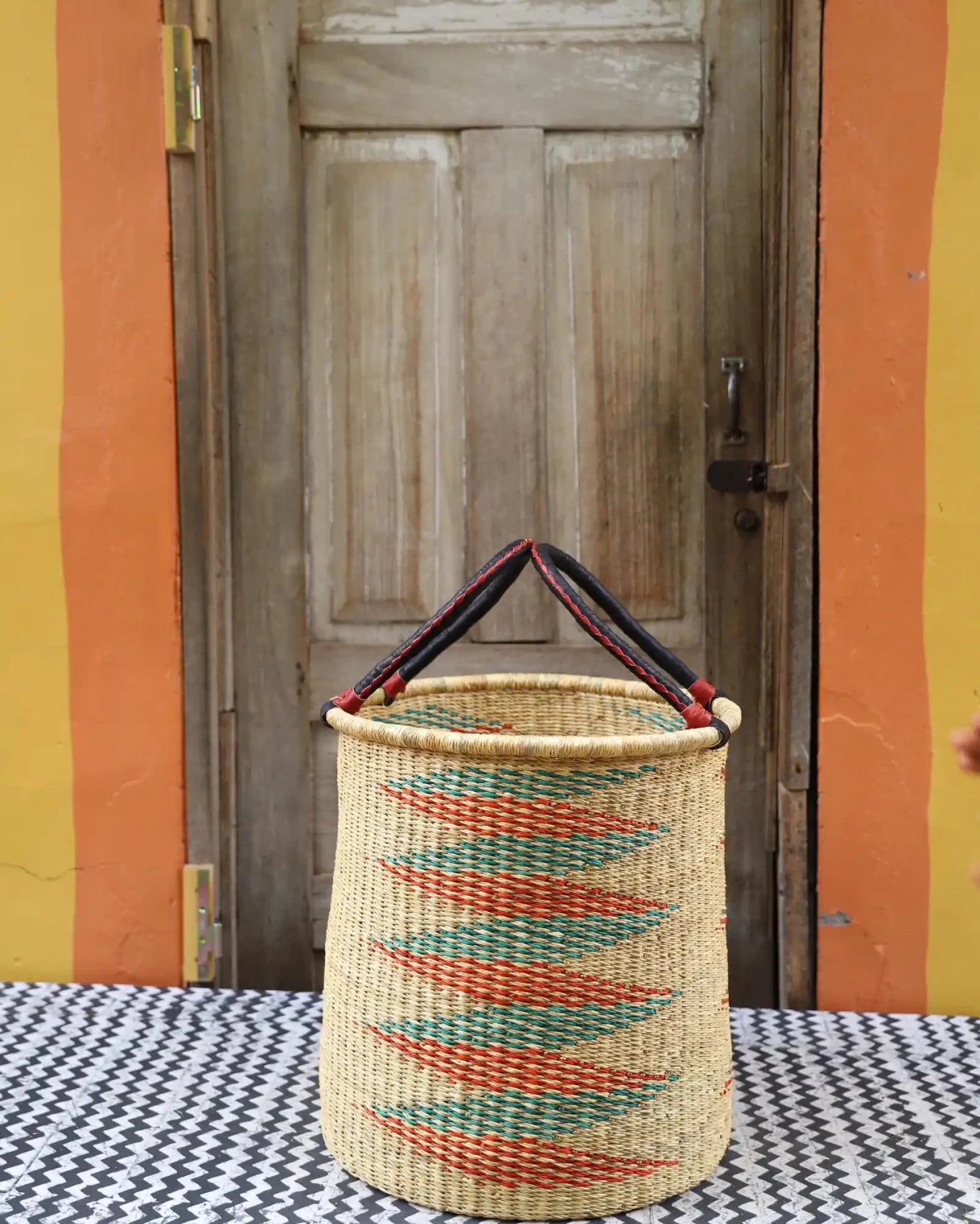 Open Laundry Basket (Medium) by The Baba Tree. Handwoven elephant grass storage with leather handles. Bolgatanga artisan decor.