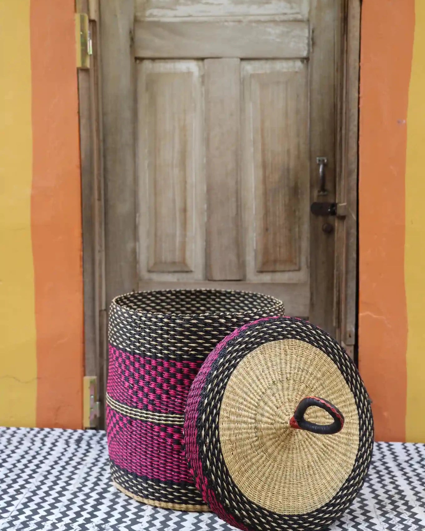 Lidded Laundry Basket (Medium) by The Baba Tree. Handwoven elephant grass with leather handle. Premium Bolgatanga artisan decor.l
