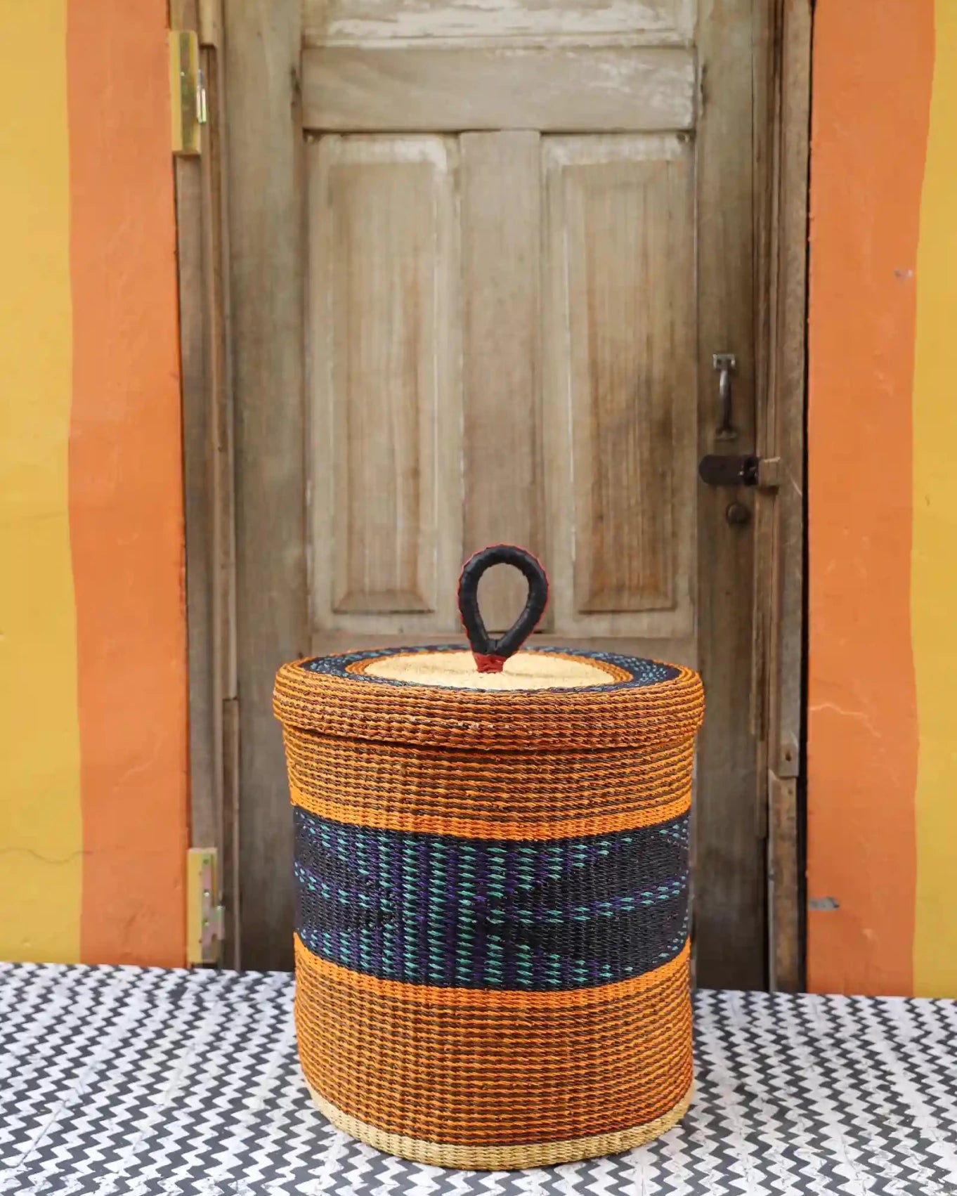 Lidded Laundry Basket (Medium) by The Baba Tree. Handwoven elephant grass with leather handle. Premium Bolgatanga artisan decor.l