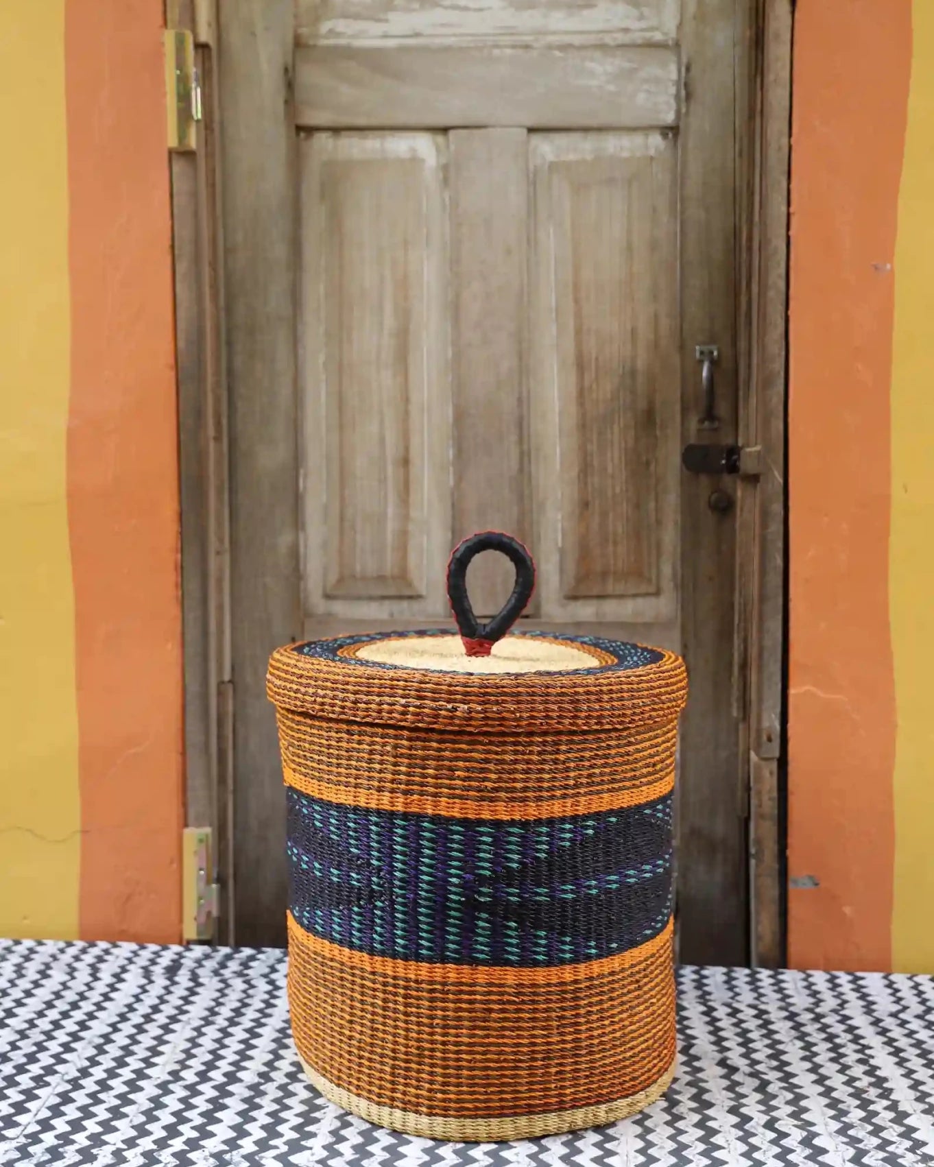 Lidded Laundry Basket (Medium) by The Baba Tree. Handwoven elephant grass with leather handle. Premium Bolgatanga artisan decor.l