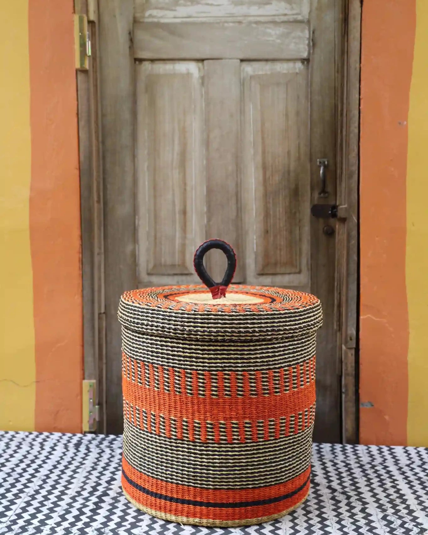 Lidded Laundry Basket (Large) by The Baba Tree. Handwoven elephant grass with leather handle. Premium Bolgatanga artisan decor.