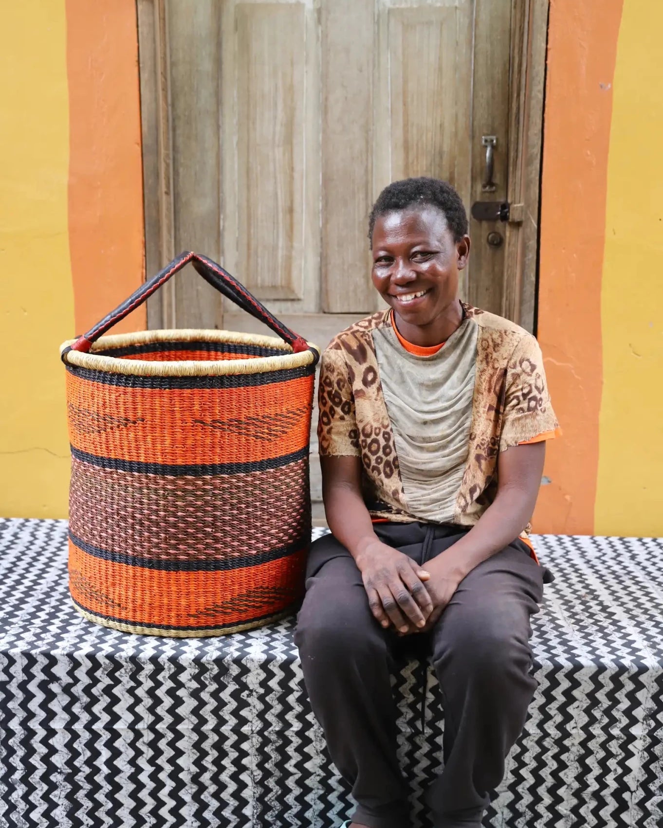 Open Laundry Basket (Medium) by The Baba Tree. Handwoven elephant grass storage with leather handles. Bolgatanga artisan decor.