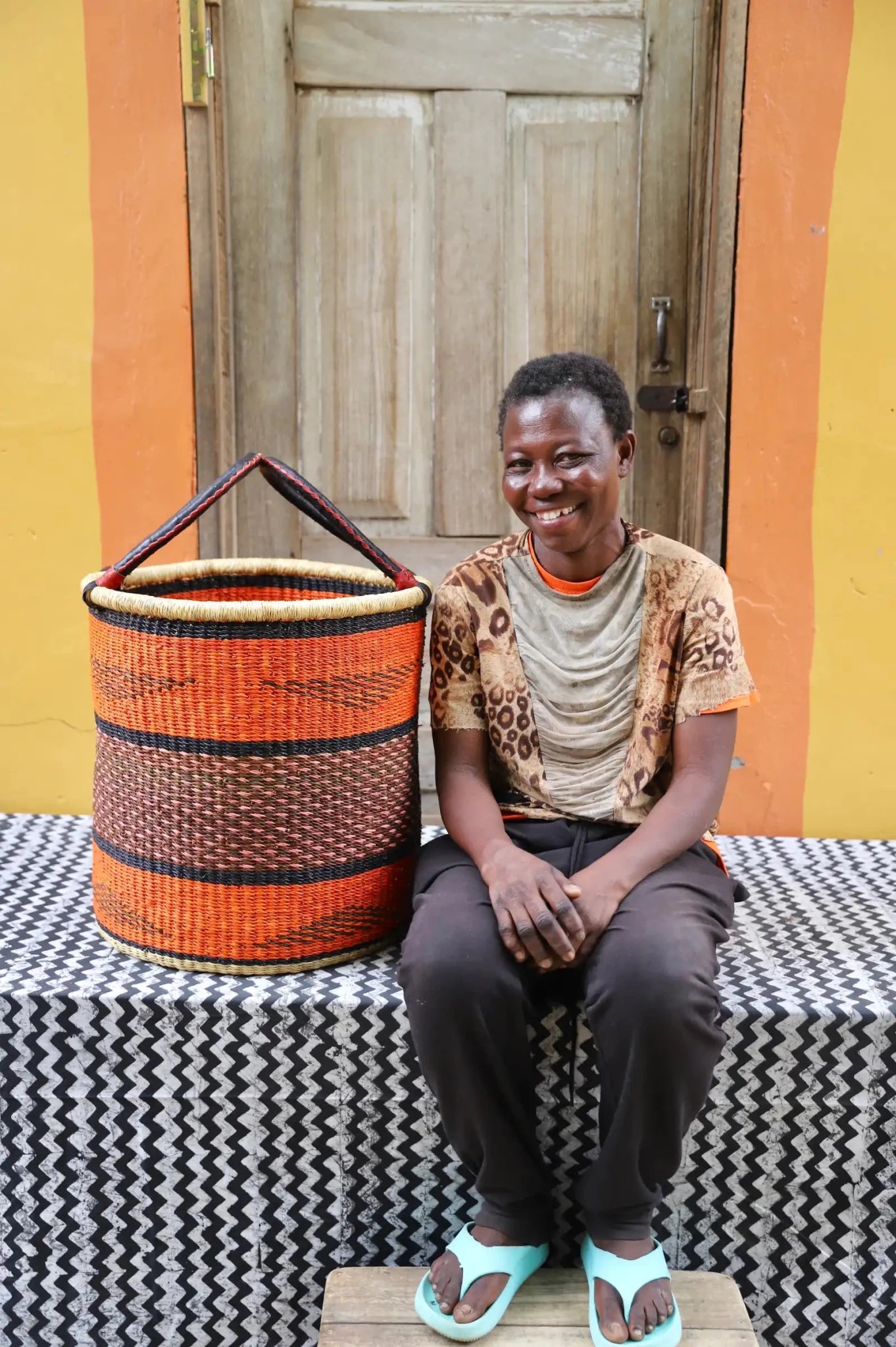 Open Laundry Basket (Medium) by The Baba Tree. Handwoven elephant grass storage with leather handles. Bolgatanga artisan decor.
