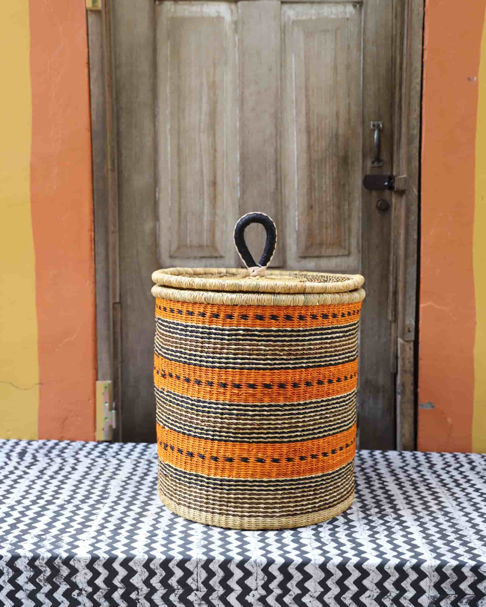 Lidded Laundry Basket with coil (Medium) by The Baba Tree. Handwoven elephant grass with leather handle. Premium Bolgatanga artisan decor.