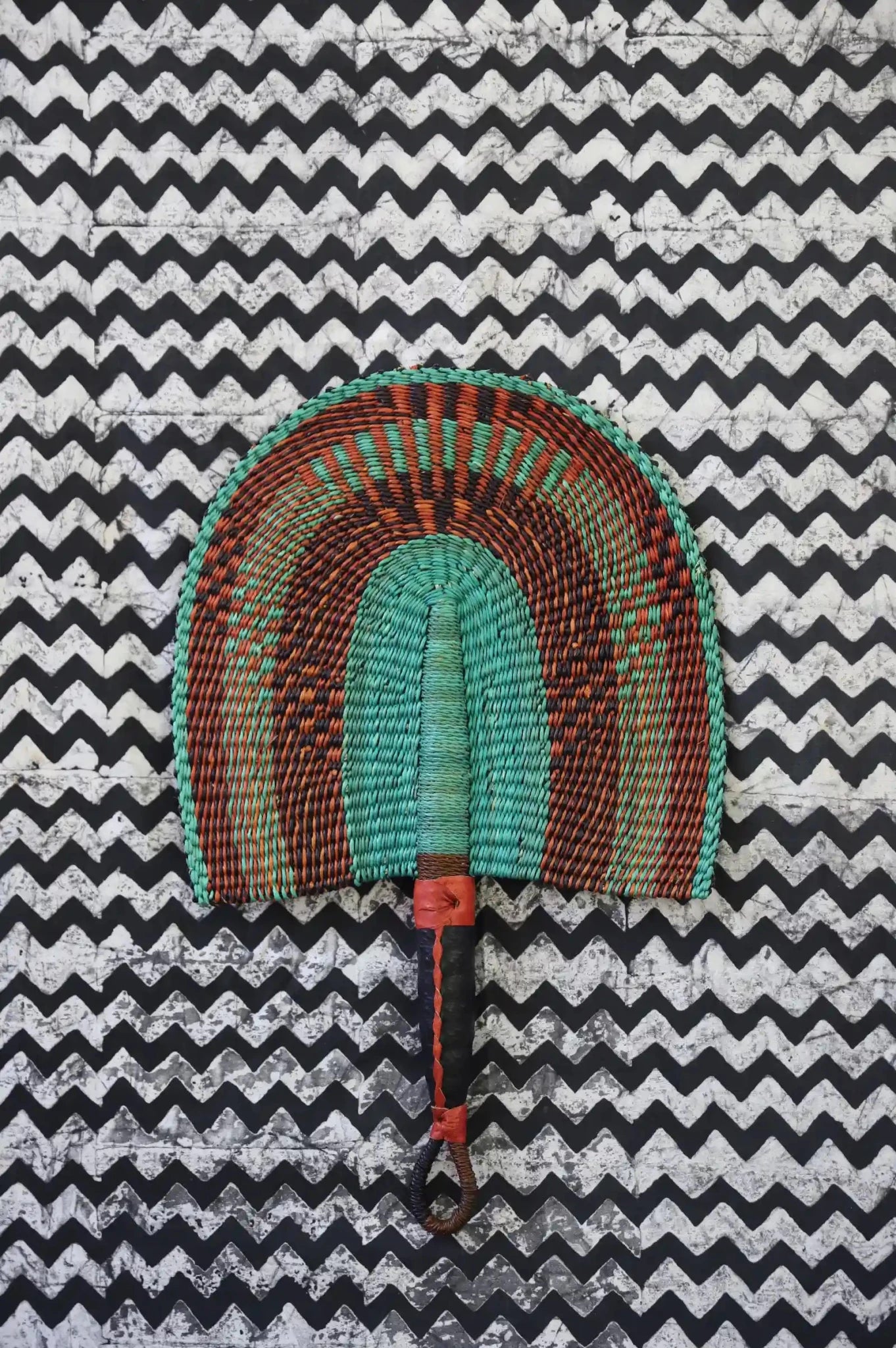 The Baba Tree Bolga Original Fan: Handwoven architectural wall art with intricate weave and premium leather handle.