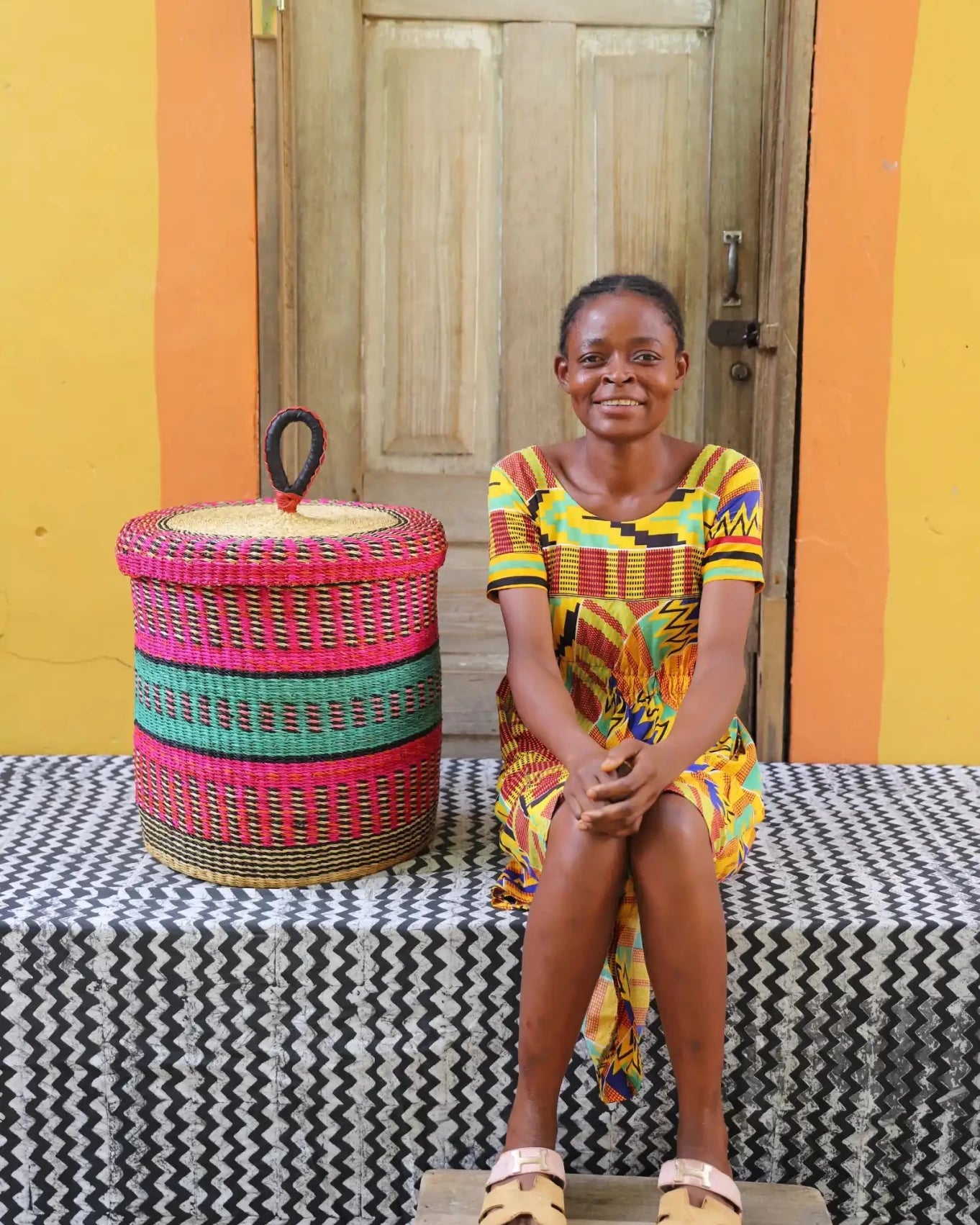 Lidded Laundry Basket (Small) by The Baba Tree. Handwoven elephant grass with leather handle. Premium Bolgatanga artisan decor.
