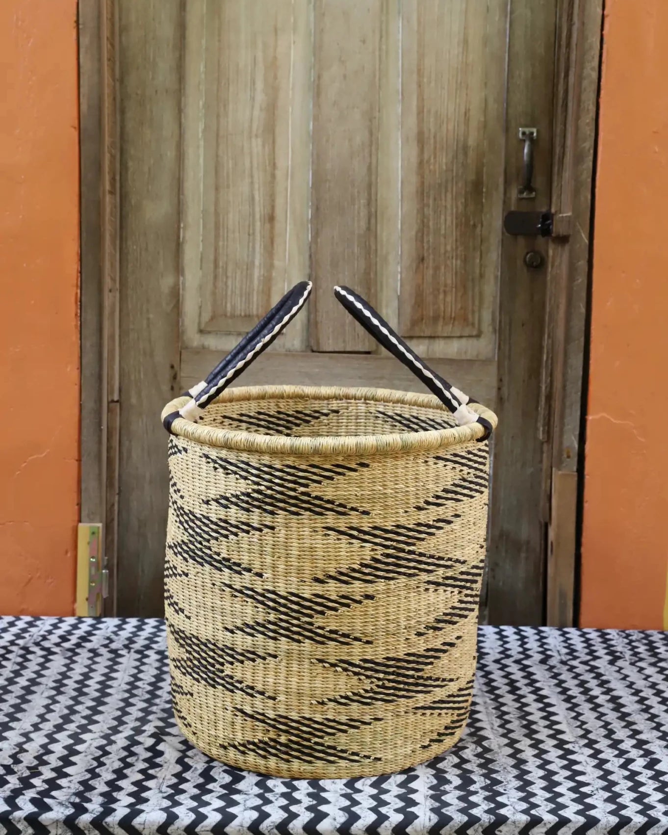 Open Laundry Basket (Small) by The Baba Tree. Handwoven elephant grass storage with leather handles. Bolgatanga artisan decor.